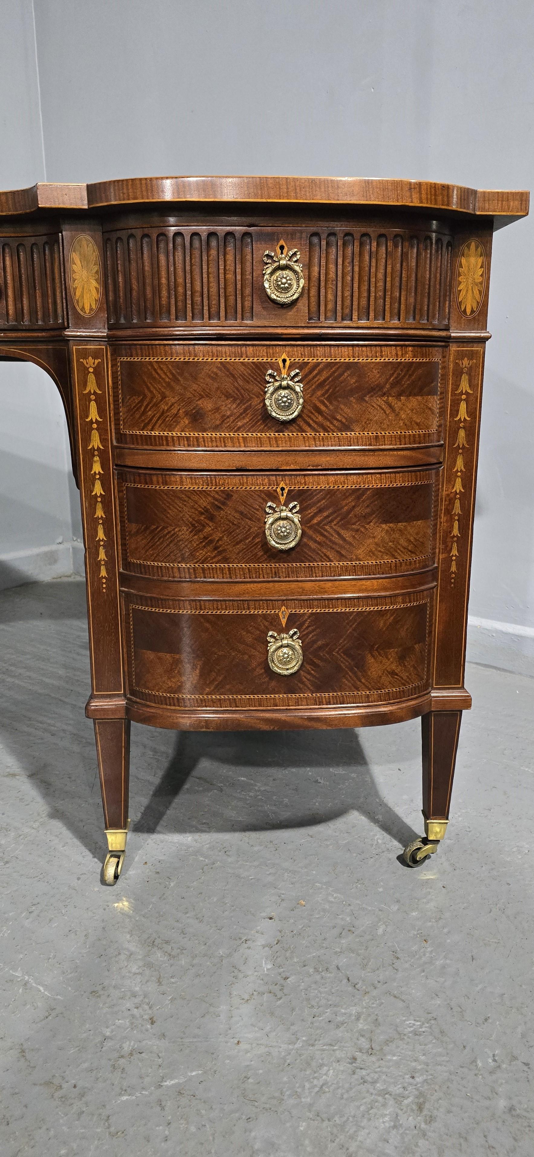 Outstanding Adams style inlaid desk on the large side, black leather and figured mahogany inlaid top, three reeded freize drawers the central one with inlaid harebell urn, bow fronted  pedestal drawers, three to one side,two to the other, all