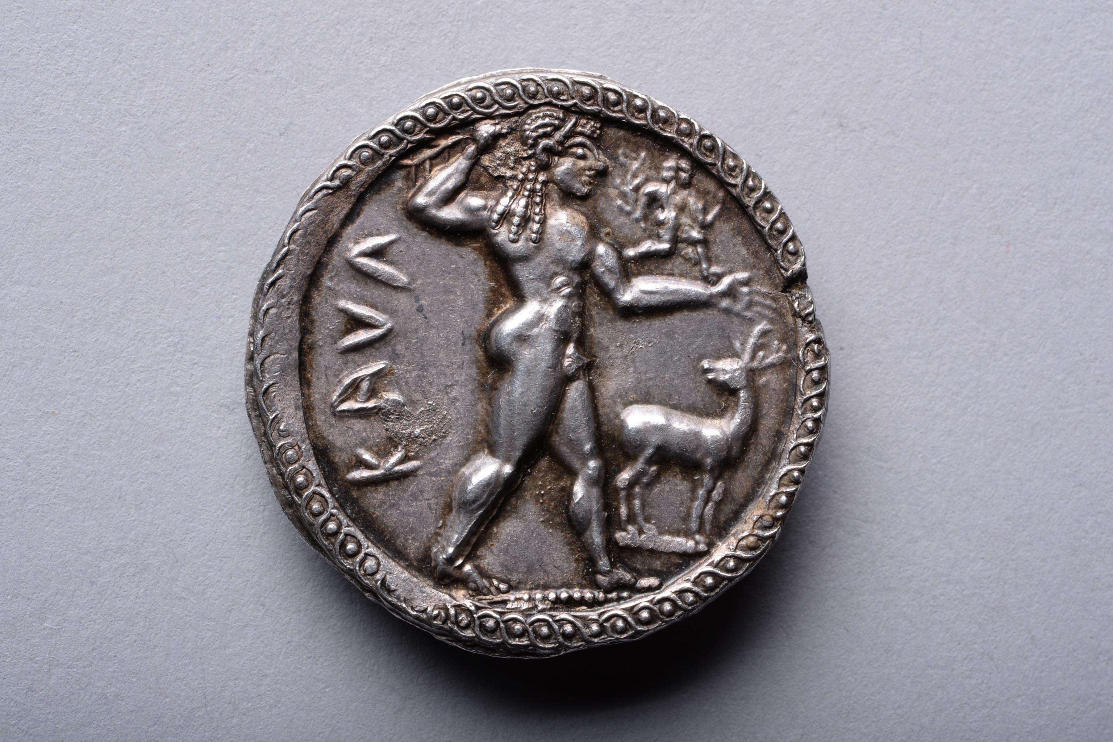 A masterpiece of late archaic art. Silver stater from Kaulonia, Bruttium, circa 525-500 BC.
 
The obverse with a nude cult statue of Apollo, wearing diadem and carrying a laurel branch in his right hand, a small running figure of a daimon with