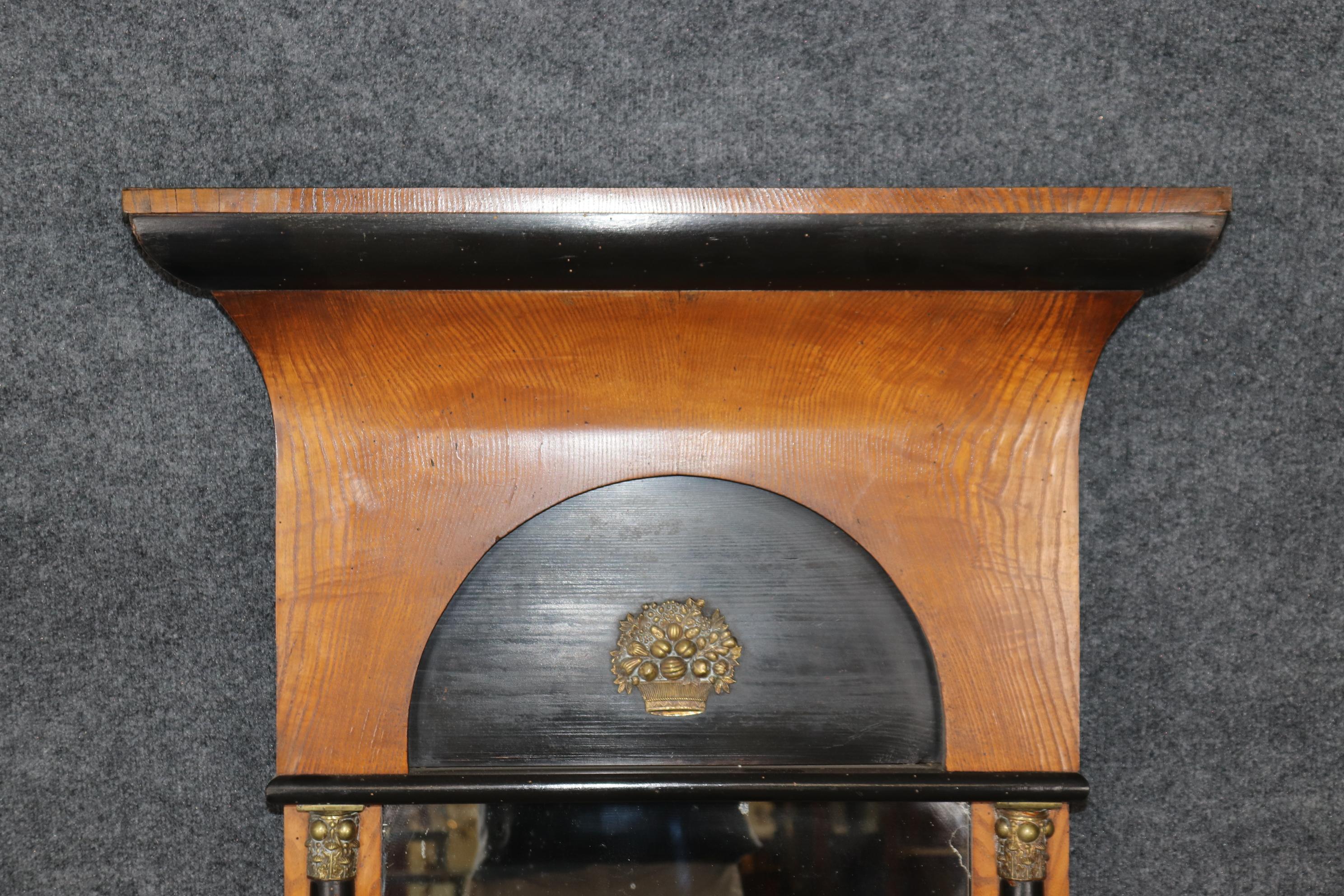 This is a gorgeous genuine Biedermeier mirror made of ash wood and ebonized with solid bronze or cast brass details and columns. The mirror plate is in good condition as is the frame. The overall proportions, condition and design elements of the
