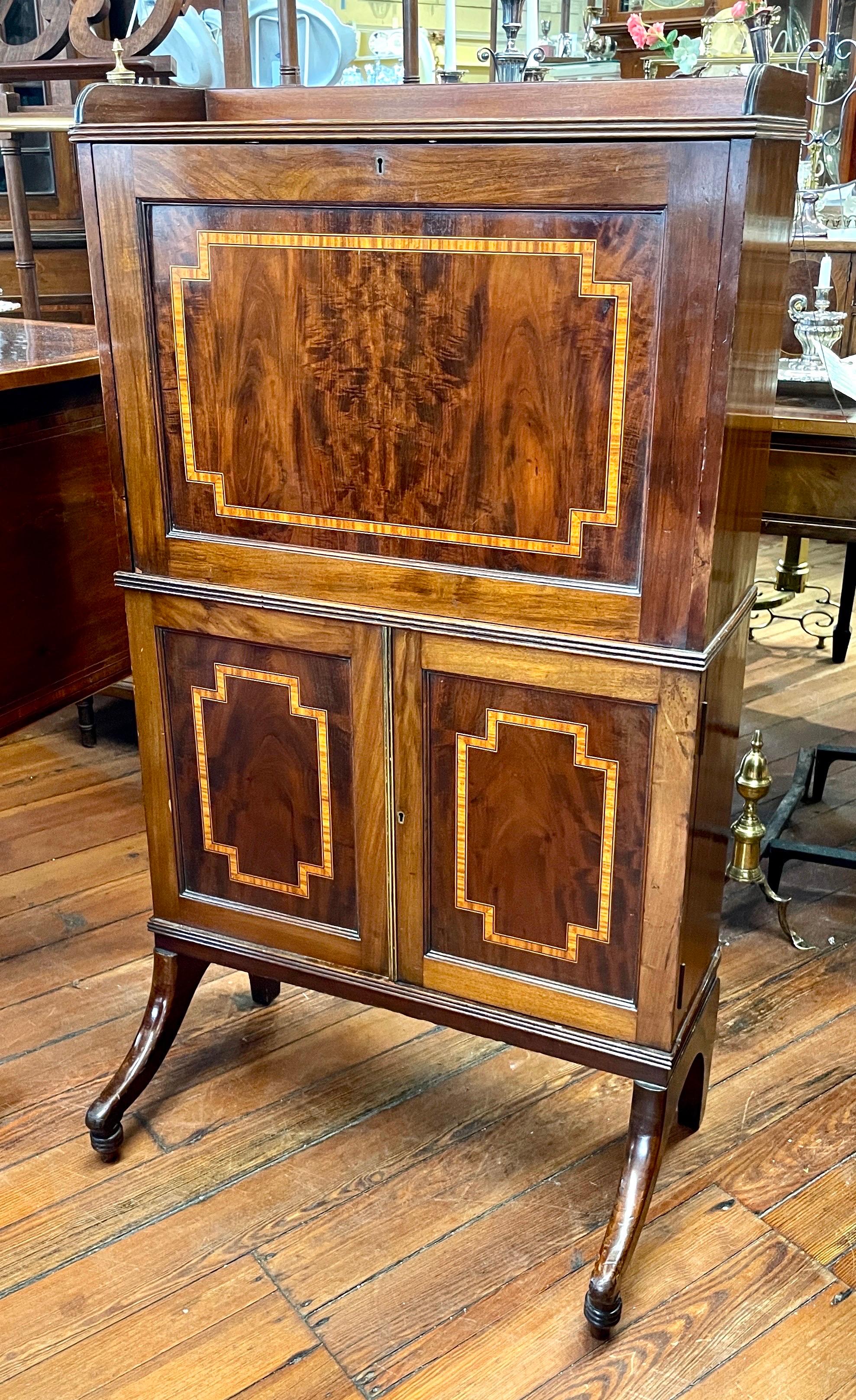This is a wonderful and rare Antique English small or diminutive Abbatant a' Secretaire or Bonheur du Jour Writing Table and is unique and wonderful.  The exterior is exquisitely made from bookmatched flame or crotch mahogany with a wide banding of