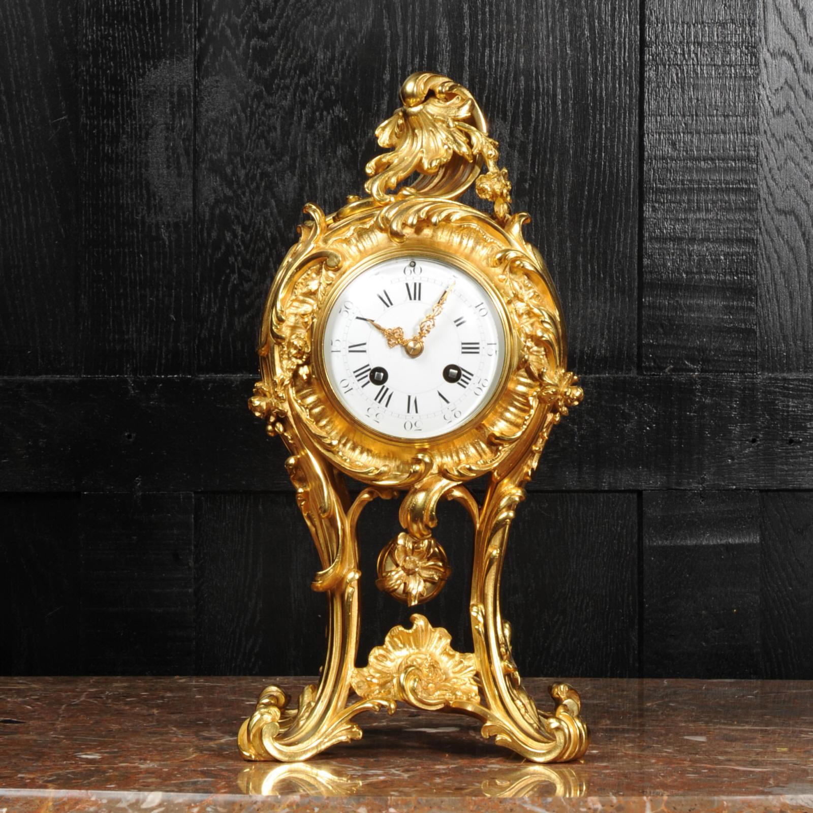 A stunning antique French clock, circa 1870, finely modelled in ormolu (finely gilded bronze). It is a beautiful Rococo balloon shape with boldly flamboyant acanthus legs hold the movement aloft. The original ormolu pendulum swings gently below.