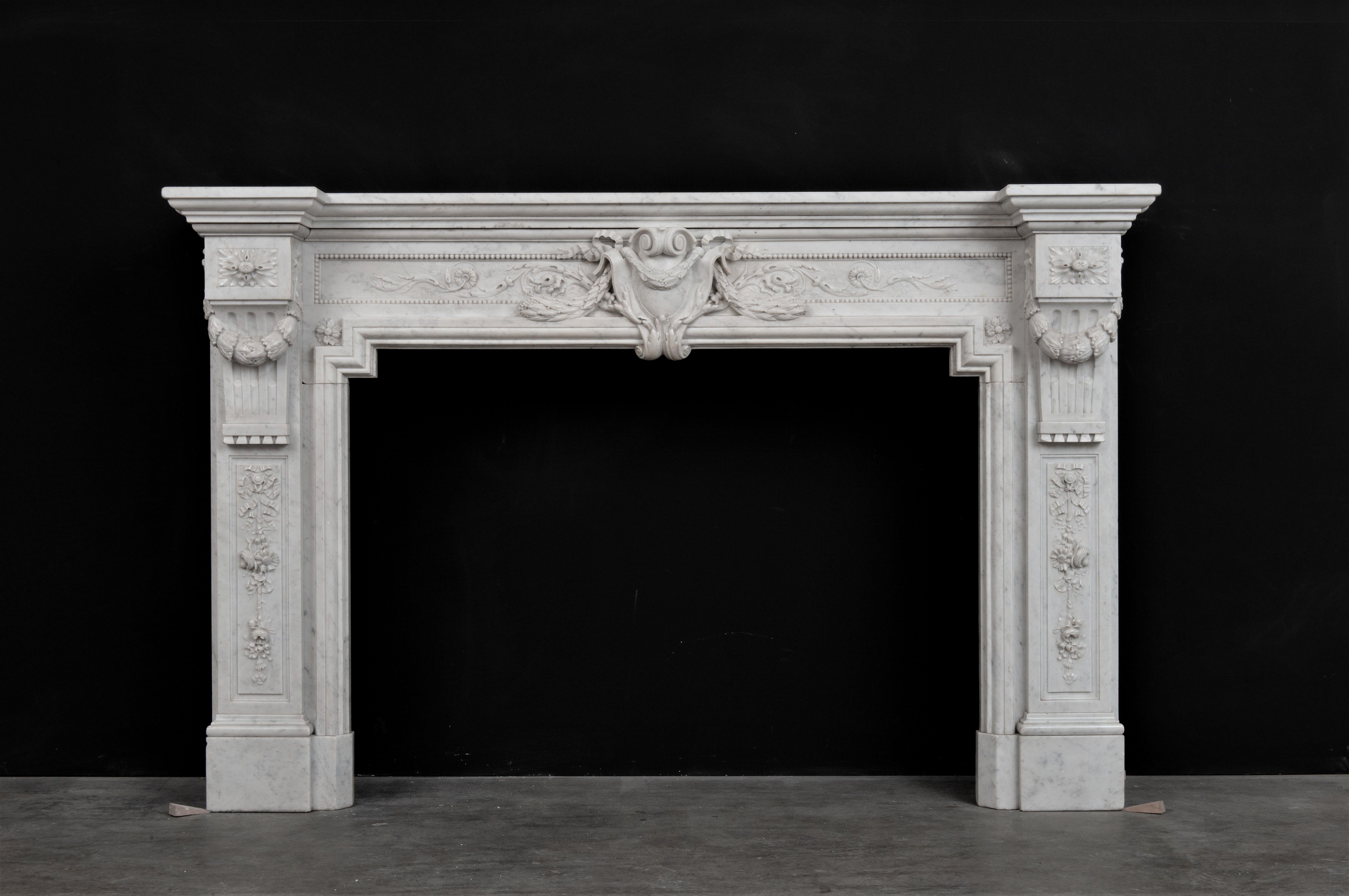 Spectacular French Louis XVI style fireplace mantel in beautiful Italian Carrara white marble.

This mantel is decorated with exquisite and exuberant carvings. It is in a lovely condition and ready to be installed. 
 
The opening dimensions