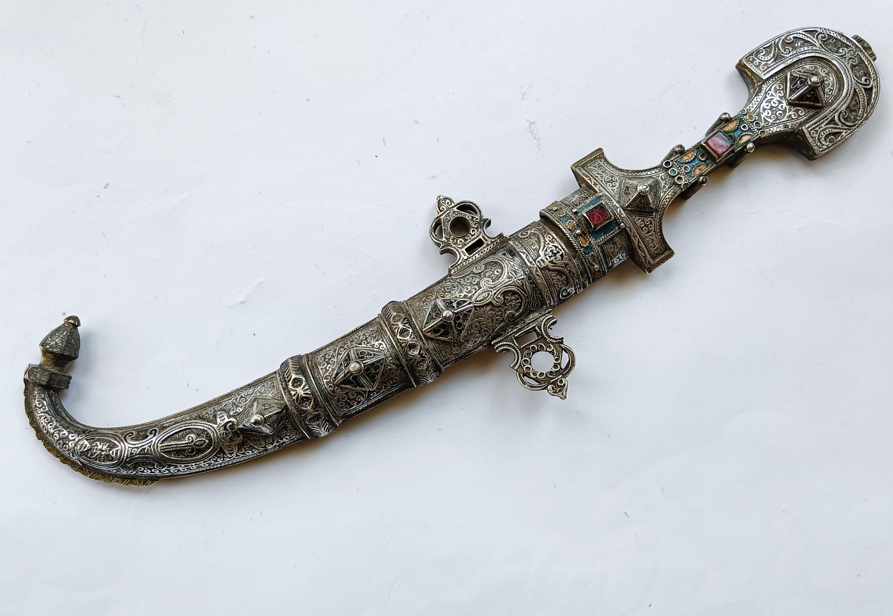 Superb Antique Moroccan Koumiya Berber Dagger
 
A rare and superb example of a Moroccan Koumiya Berber Dagger with highly ornate silver and brass work  and gem stones. 
period 19th century
Height 38 cm


   