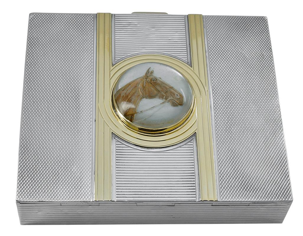 Beautiful sterling silver box with allover fine line engine-turned pattern.  Intersecting 14K yellow gold stripes.  The center is set with a large Essex crystal of a horse's head.  3