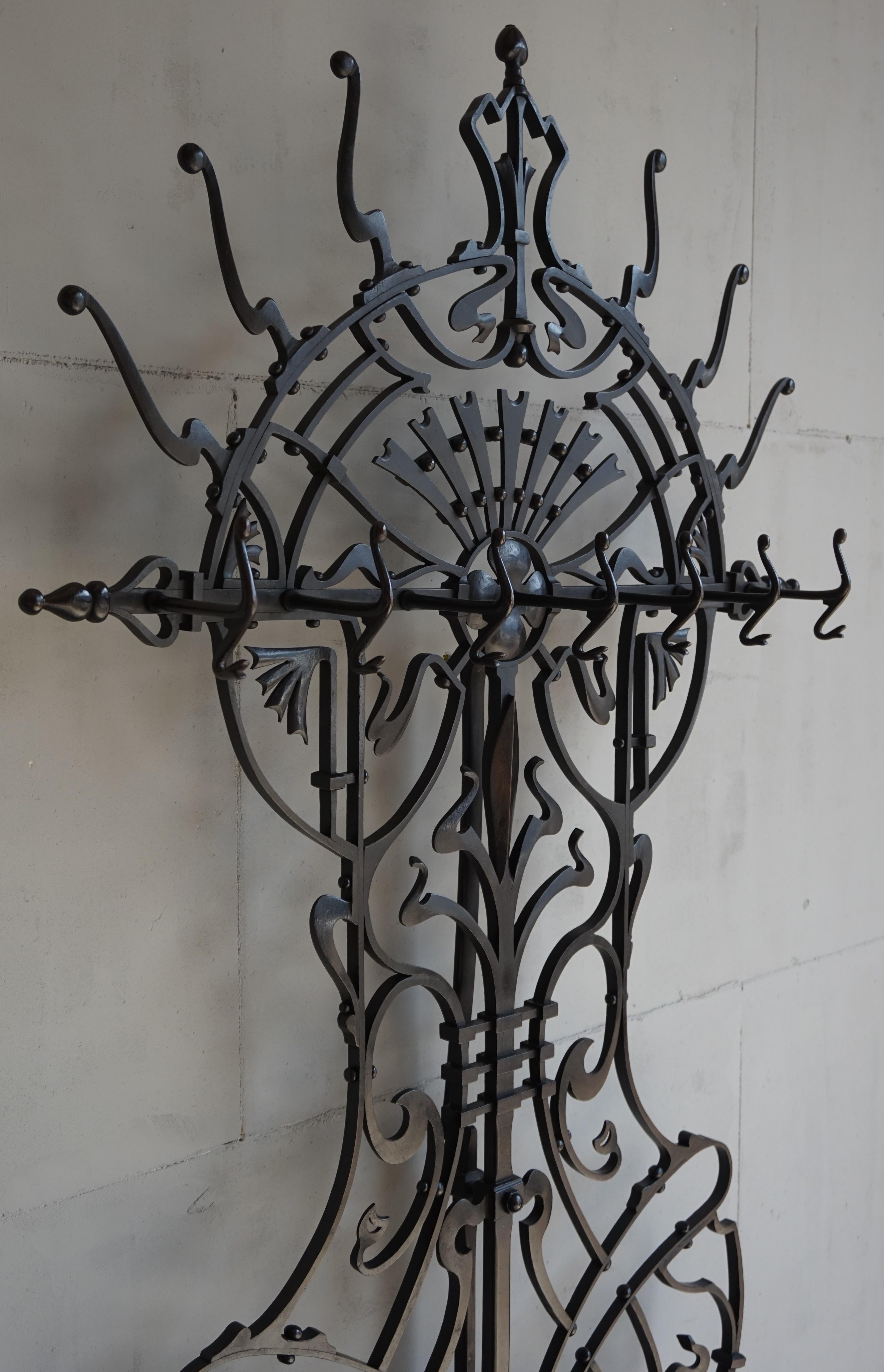 Incredible workmanship antique coat rack & stick stand.

Over the years we have seen and sold a number of unique and top quality antiques made of wrought iron, but this is by far the best we have ever seen. The Arts & Crafts design of this large and