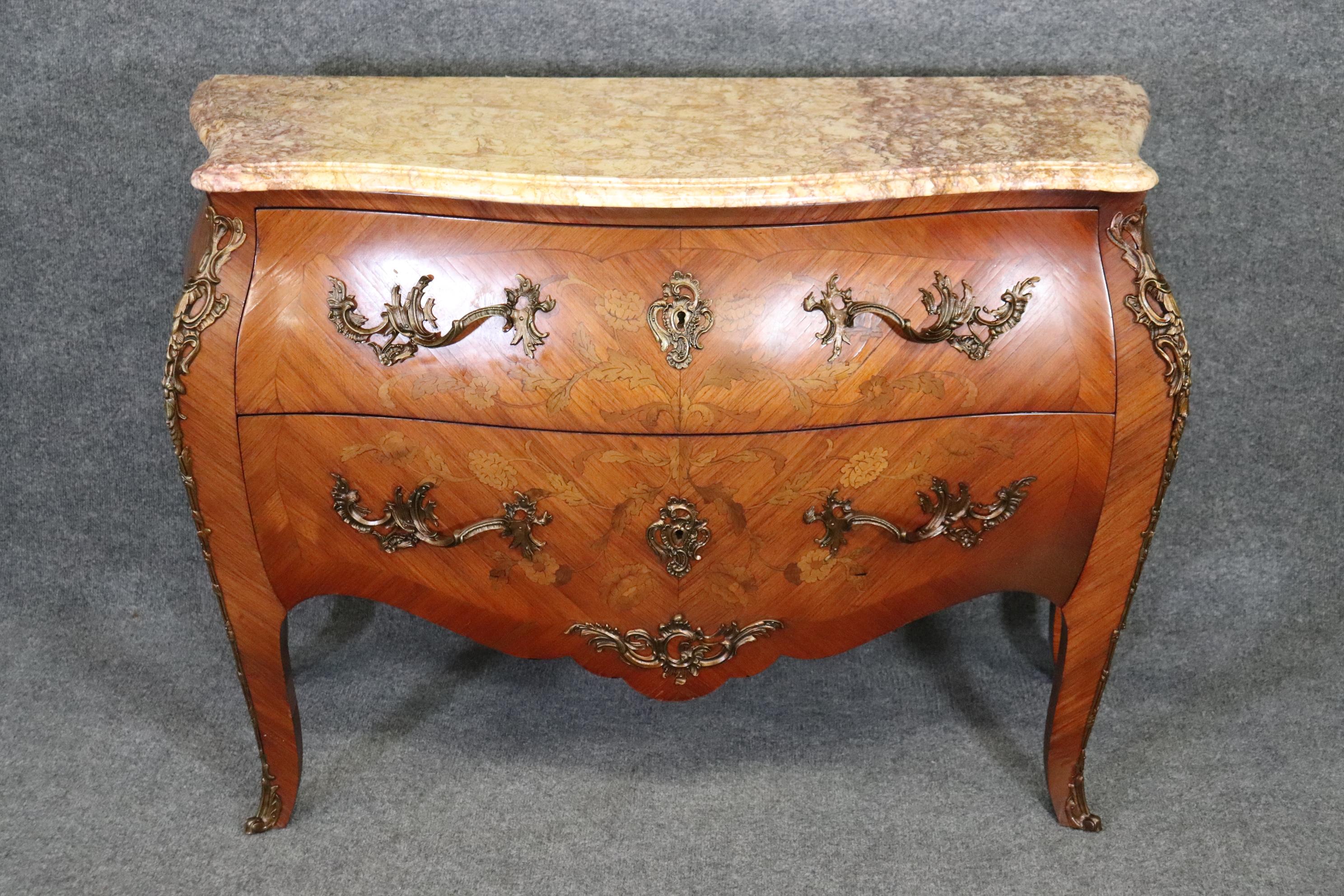 This is a stunning piece of French Louis XV style furniture with the best marble top and gorgeous beefy bronze omorlu and inlay. The marble top is that gorgeous lavender to yellow marble top. The case is inlaid in mixed woods and made of satinwood.