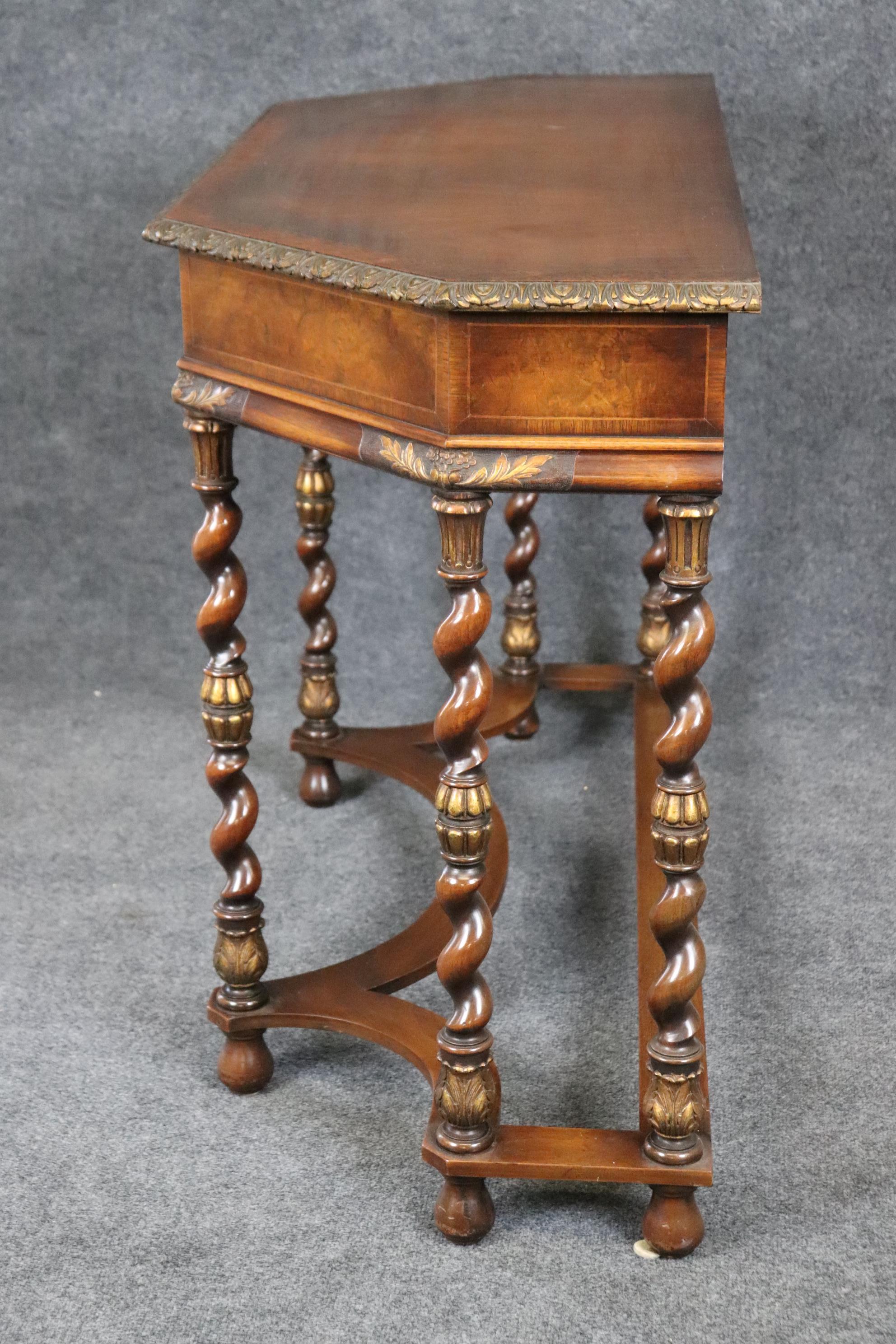 This is a fantastic carved burled walnut banded tp and barley twist leg console table. The table is in its original finish and features a shallow depth of only 20 inches. The gorgeous wood combined with the beautifully carved details and legs offer