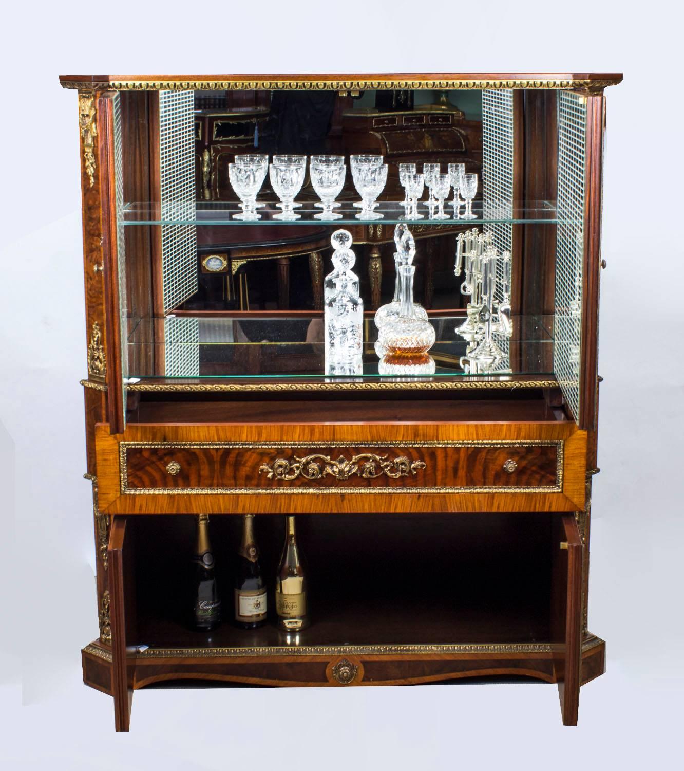 This is a superb large French Louis revival burr walnut and kingwood ormolu-mounted cocktail cabinet, mid-20th century in date. 

Adding to its truly unique character it has been decorated with a plethora of exquisite gilded ormolu mounts.

The