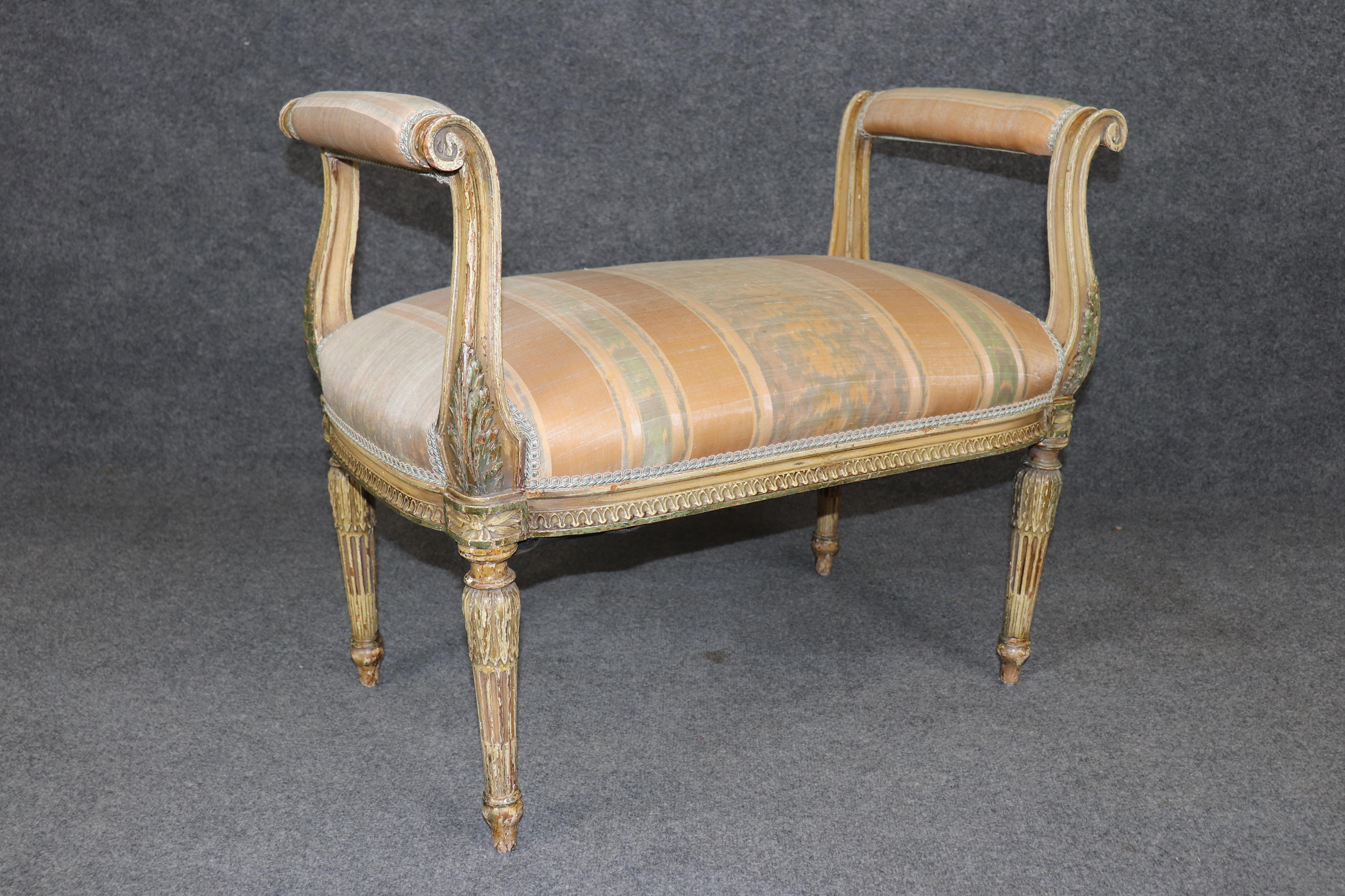 This is a special, distressed paint decorated window bench. The bench is beautifully carved and has that wonderful distressed painted finish mavens of antiques love. The upholstery and overall look of the bench is a wonderful combination of textures