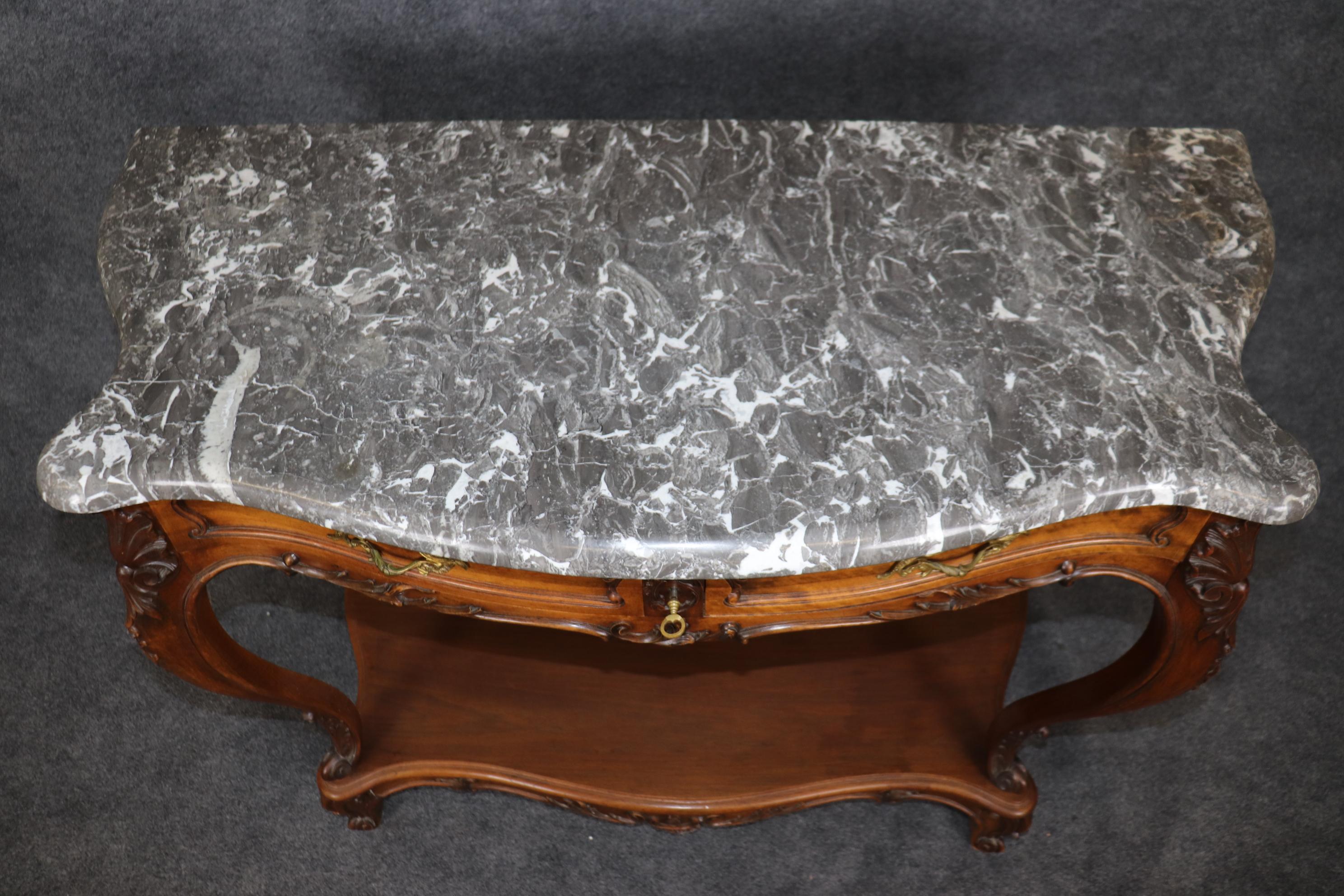 This is a very shallow depth console or buffet attributed to Mercier Freres. This is perfect for a space that can't use a full size sideboard. The piece is beautifully carved walnut with a fine patina and dazzling gray and white marble on top. The