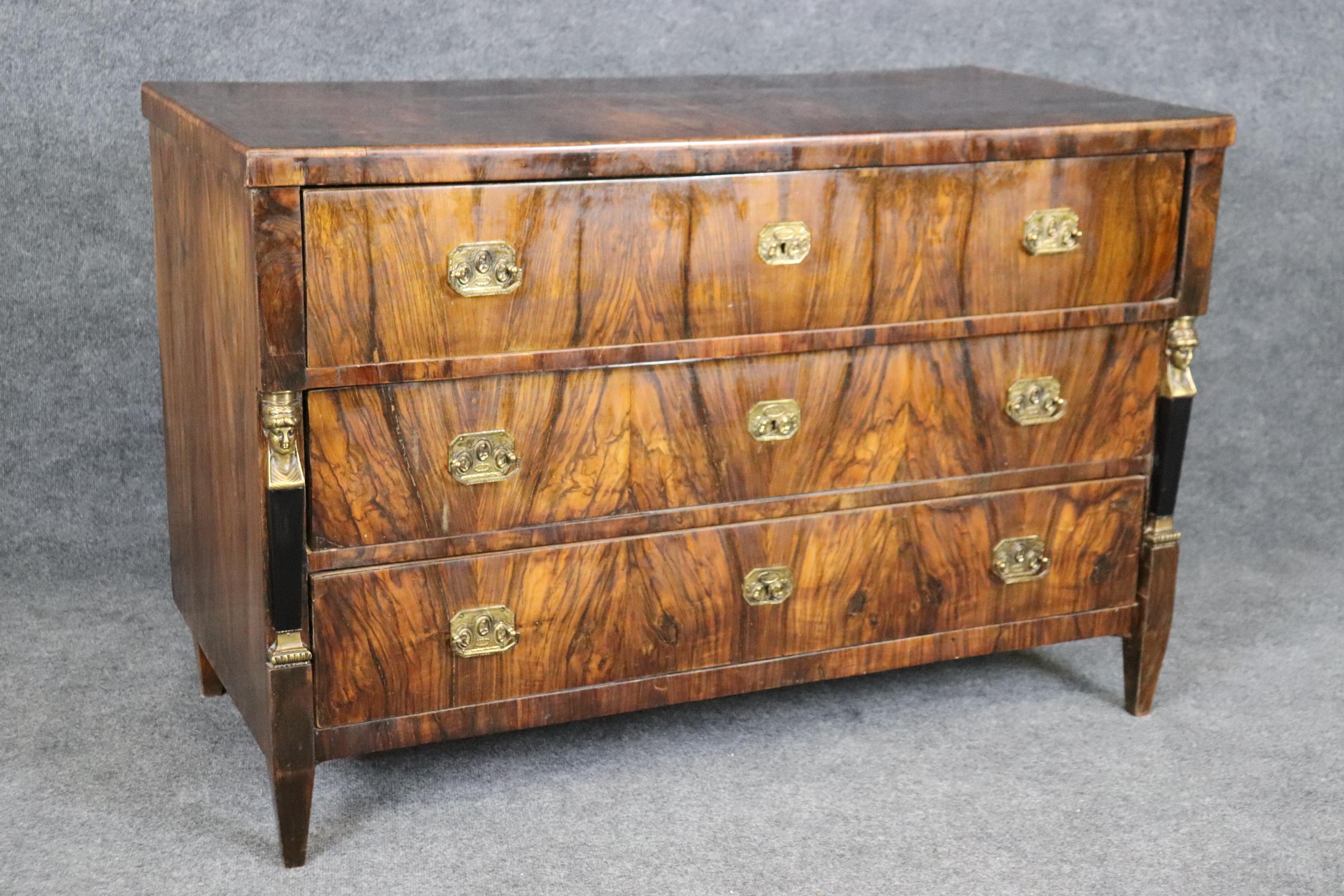 This is a fantastic, absolutely breathtaking Circassian Walnut with incredible contrasts of blacks and browns that are remiscient of rosewood. The piece features bronze figural caryatids and are surmounted towards the middle of the sides rather than
