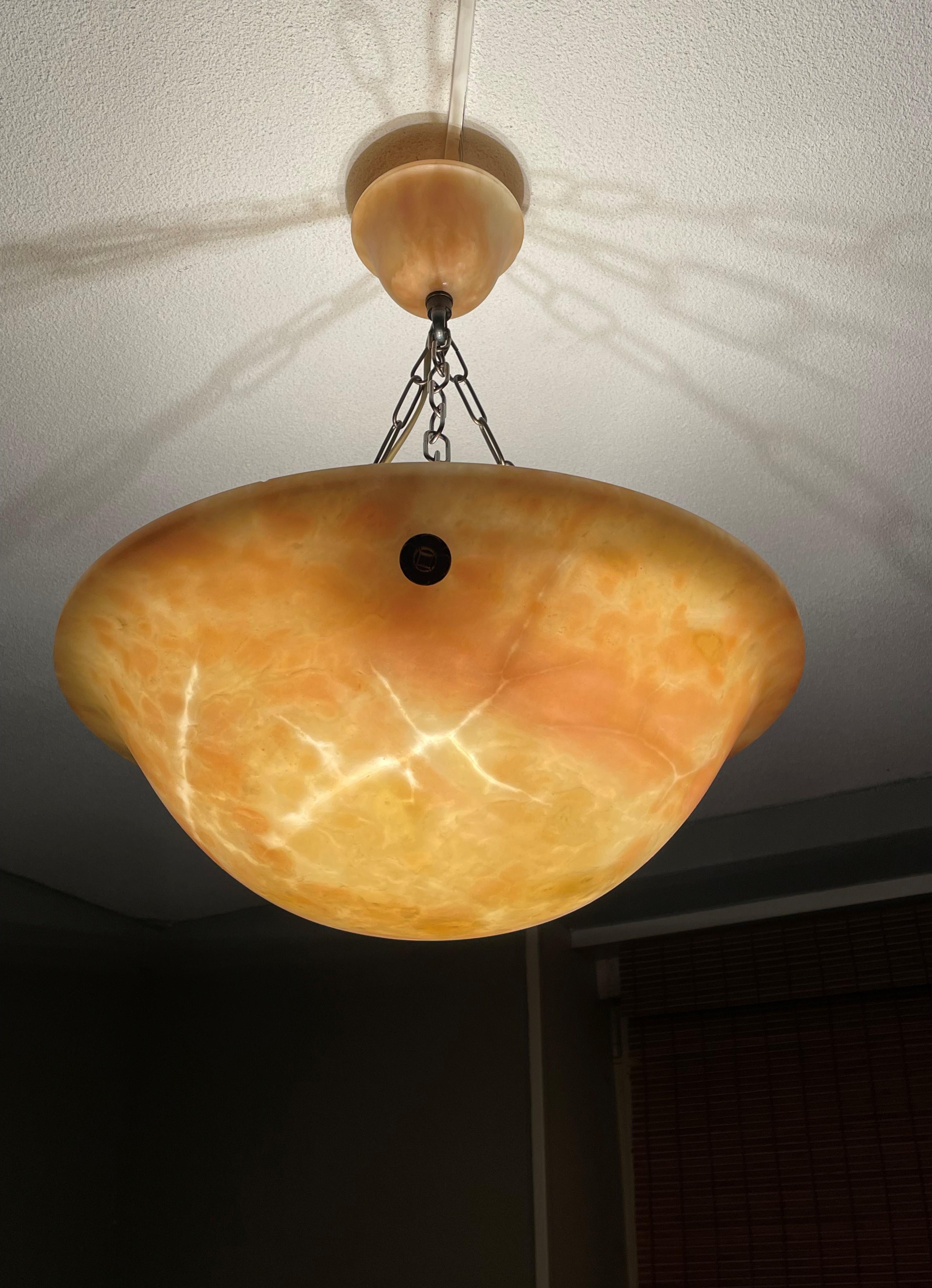 Unique 3-light alabaster pendant with amber colored patches/clouds and lightning white veins. 

One of the qualities of alabaster pendants is that no two shades will ever be exactly the same. Mother Nature created this mineral stone over the