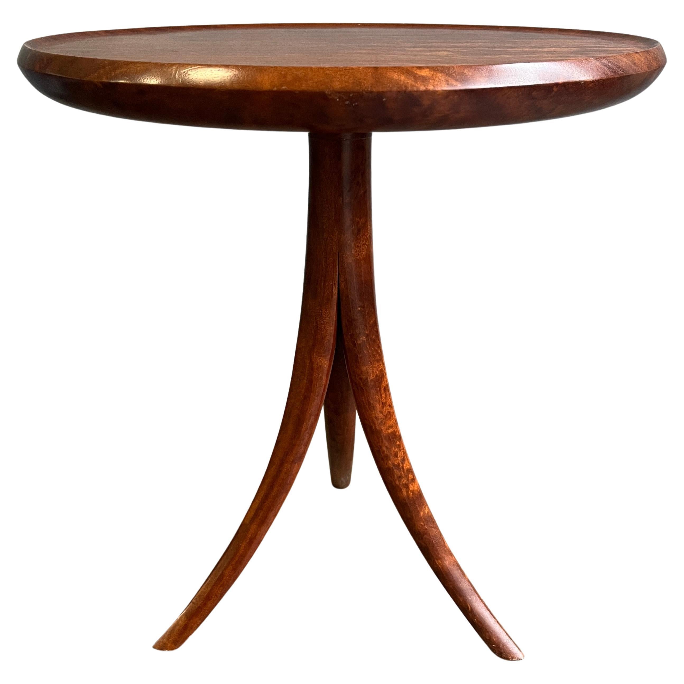 Exceptional midcentury styled tripod table with incredible figuring, likely a tropical hardwood, featuring circular dished top raised on a stylized one-piece tripod base, monogrammed and inscribed on the underside.