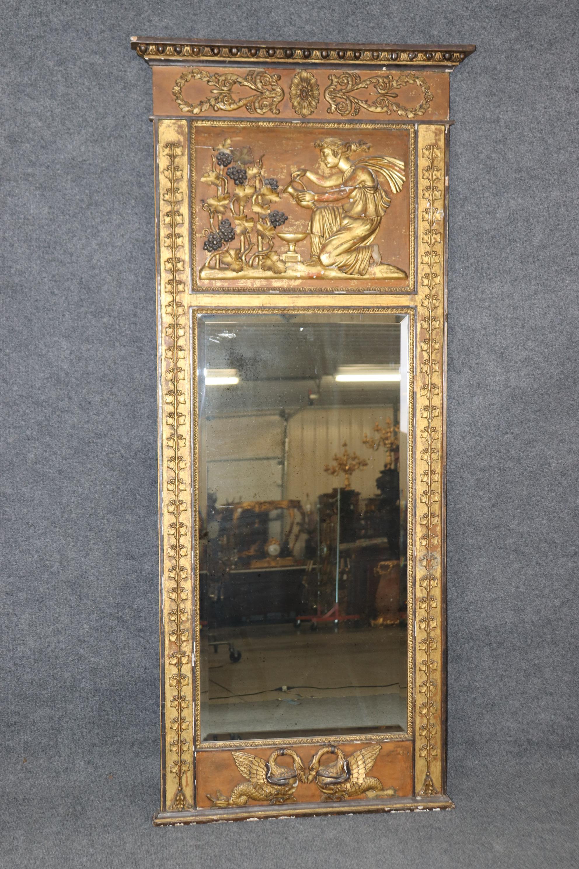 Si tratta di uno specchio eccezionale, ricco di carattere e di dettagli. La lastra a specchio in vetro smussato è pulita e chiara e la cornice, che dire! Osserva l'incredibile finitura anticata con cigni stilizzati alla base e una figura che versa
