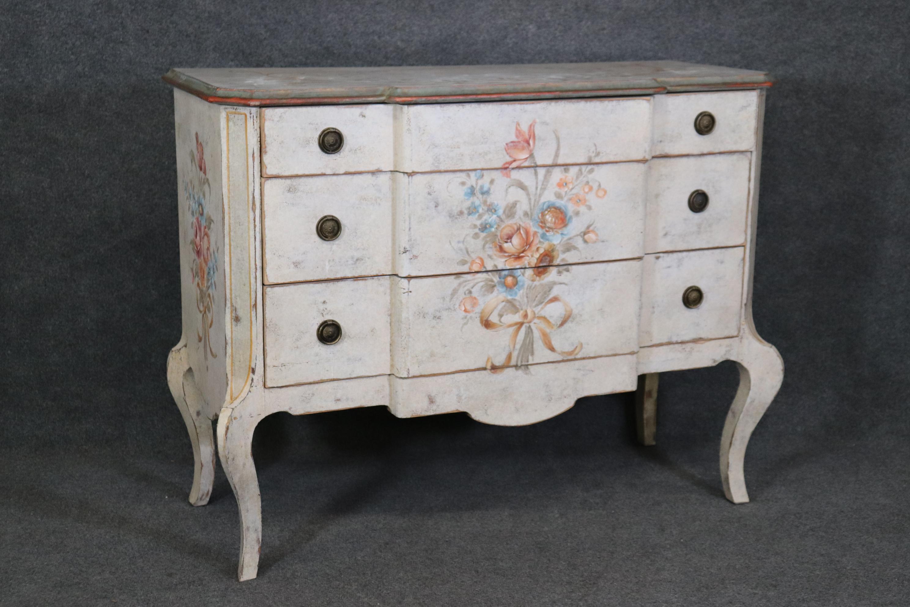 This is a fantastic time-worn distressed paint decorated commode that is designed in the Louis XV but made in Italy. The painting and distressed finish really give that beachy cottage look. The piece is an incredibly beautiful piece of art for your