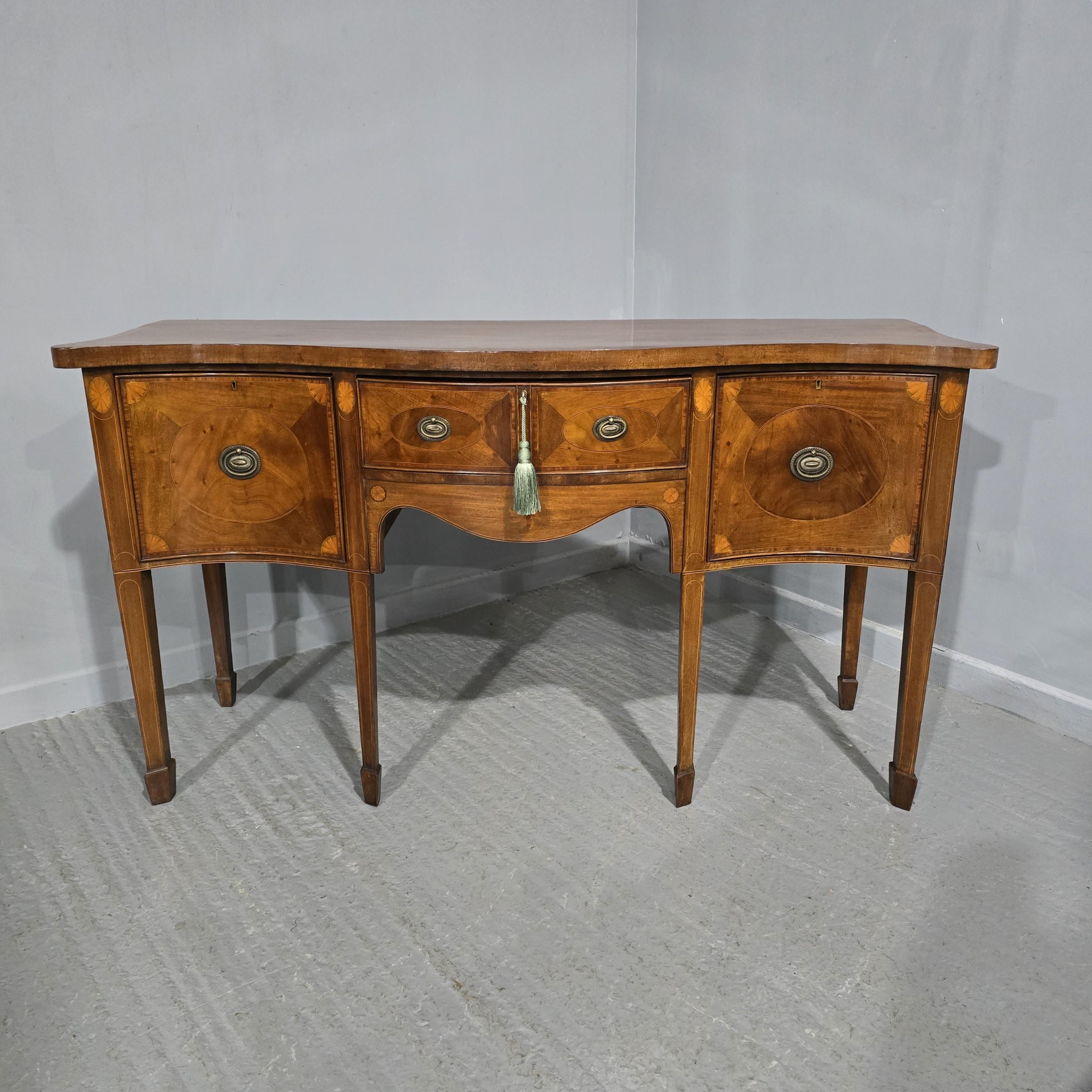 This Edwardian mahogany inlaid sideboard dates from approximately 1900. It features a bow front design and is crafted from mahogany, showcasing intricate inlay work. This piece is suitable for use as a sideboard, chiffonier, credenza, server, or