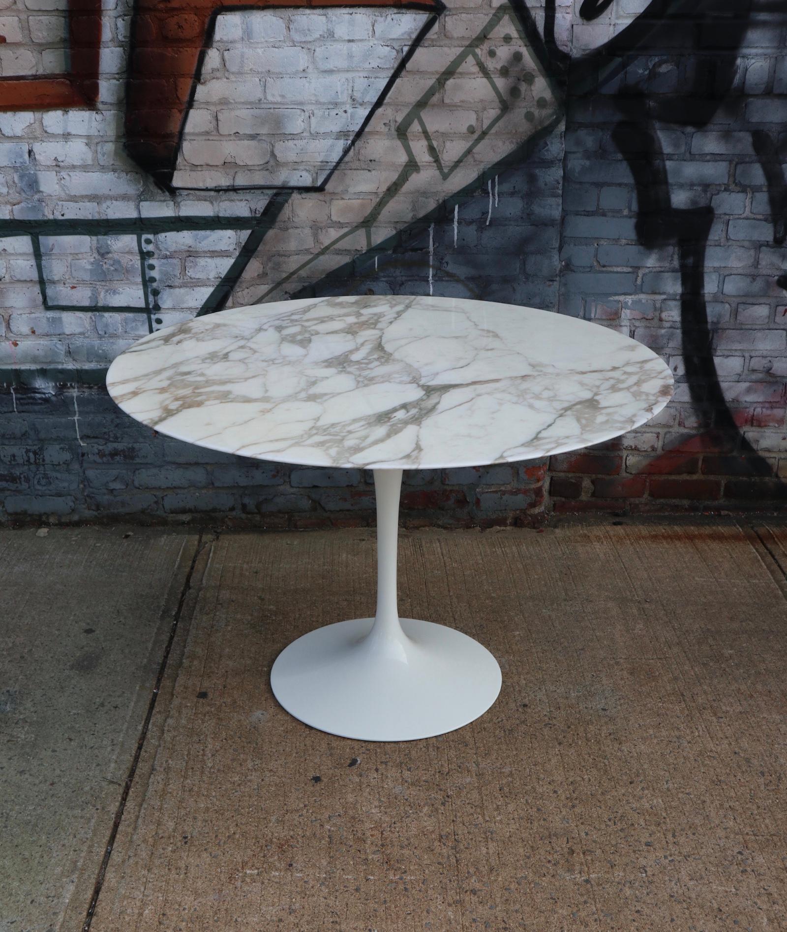 Gorgeous marble tulip dining table designed by Eero Saarinen for Knoll. In amazing condition. Cast aluminum base in white supporting divine circular top finishes in Calacatta Arabescato marble. Even and steady vein detail and color pattern. Knife