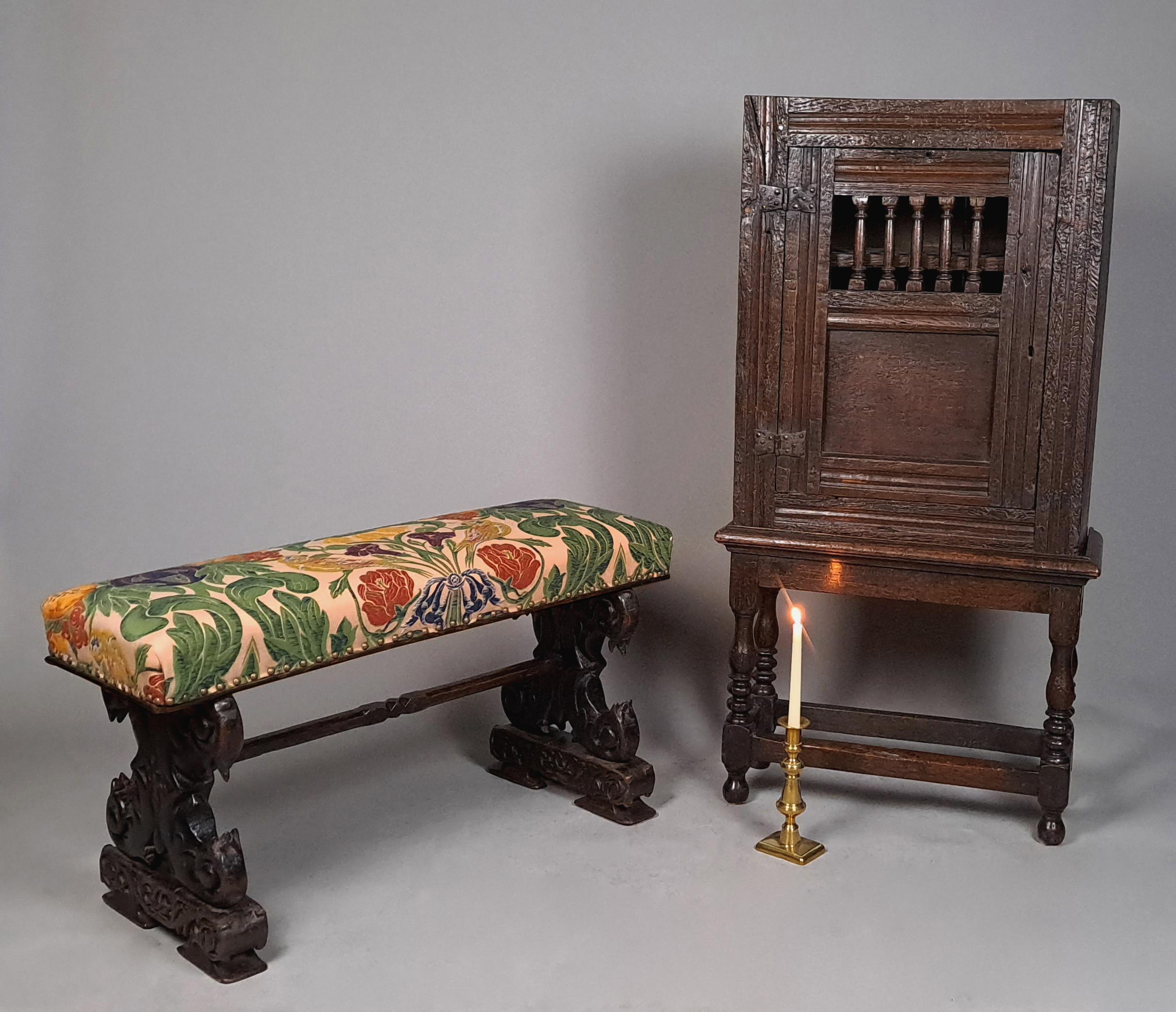 A beautiful Elizabethan long stool with carved entwined mythical beasts carved in the solid and continuous with the flared carved slab feet,  The oak of a fantastic rich colour with wonderful natural patination that glows.  These carved ends united