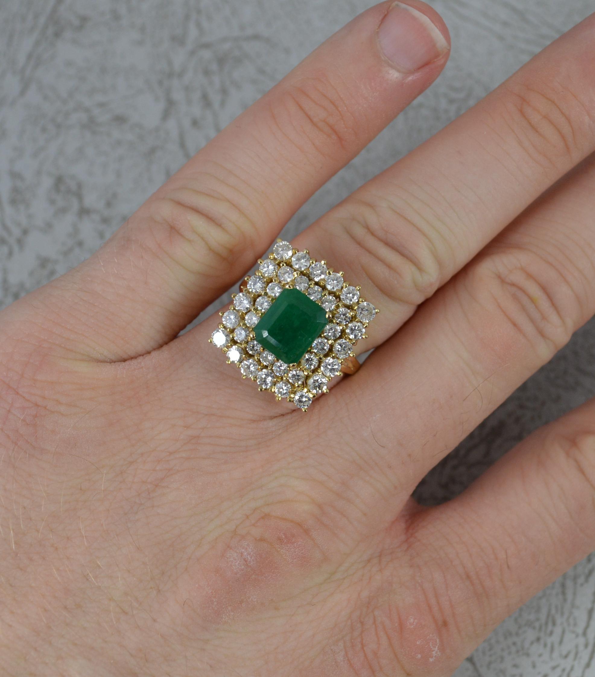 A superb emerald and diamond ring.
Solid 18 carat yellow gold example.
Designed with an emerald cut emerald to the centre, 8.2mm x 6.8mm in a four claw setting. Surrounding is a double row of round brilliant cut diamonds to total 1.50 carats. Very