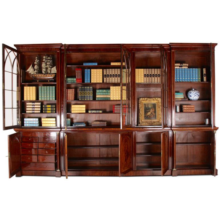 A grandly-proportioned English mid-19th century ten-door reverse-breakfront bookcase, the five upper glass doors with Gothic arch glazing pattern and opening to reveal adjustable shelves.

The lower section consists of five arched-panelled doors,