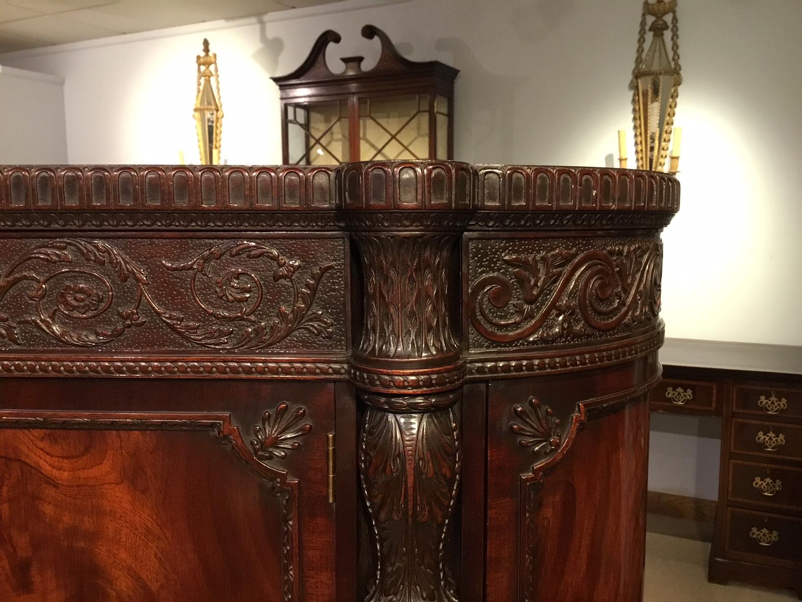 A superb exhibition quality mahogany late 19th century side cabinet after an original design by George Hepplewhite. Constructed throughout using the finest mahogany. Of bow front outline and with a finely carved frieze depicting attendant griffins