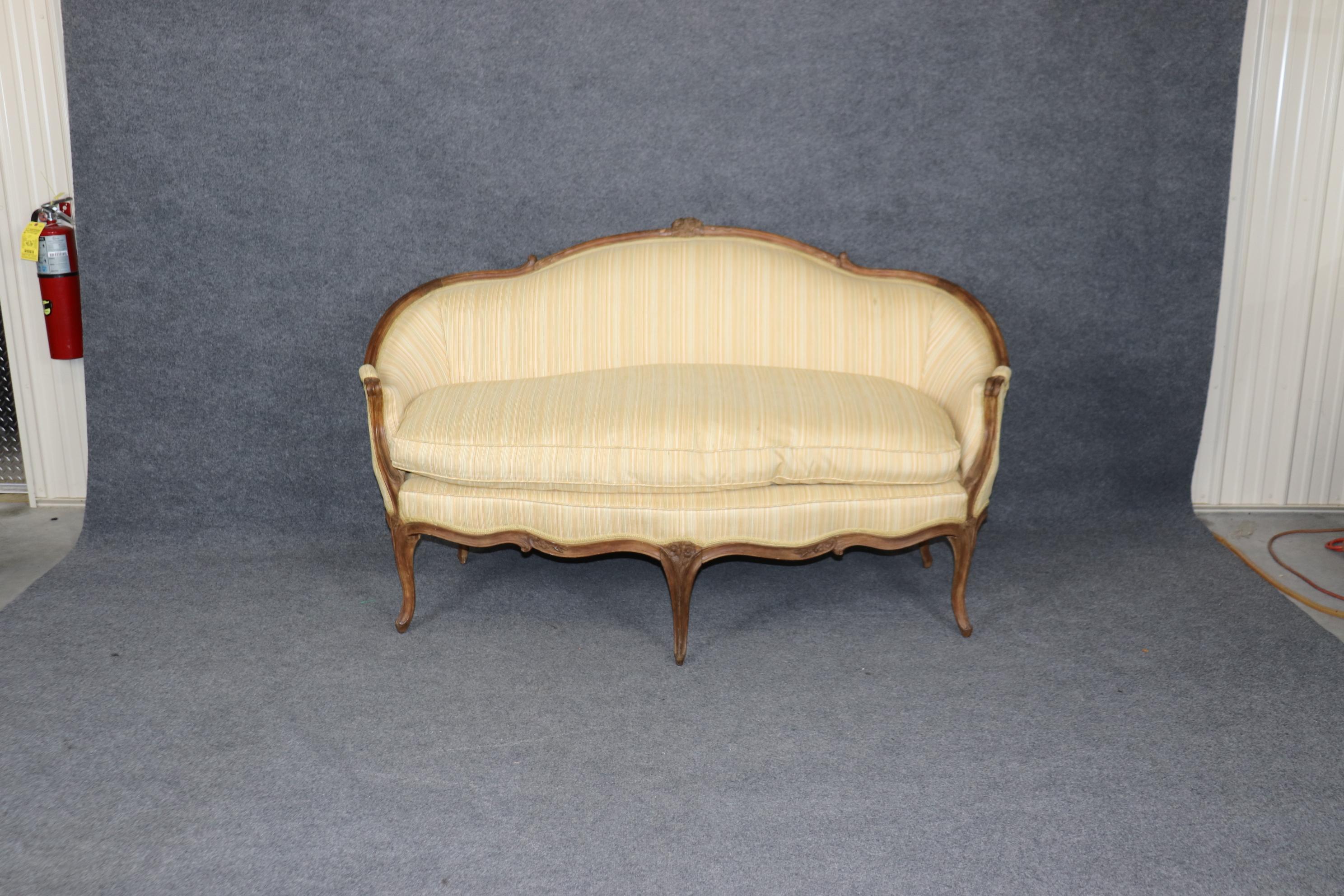This is a gorgeous hand-carved 1780ss French settee. The settee shows its original finish with its original signs of age and use and minor antique repairs. The upholstery is still quite good but does have minor signs of age and wear and stains.