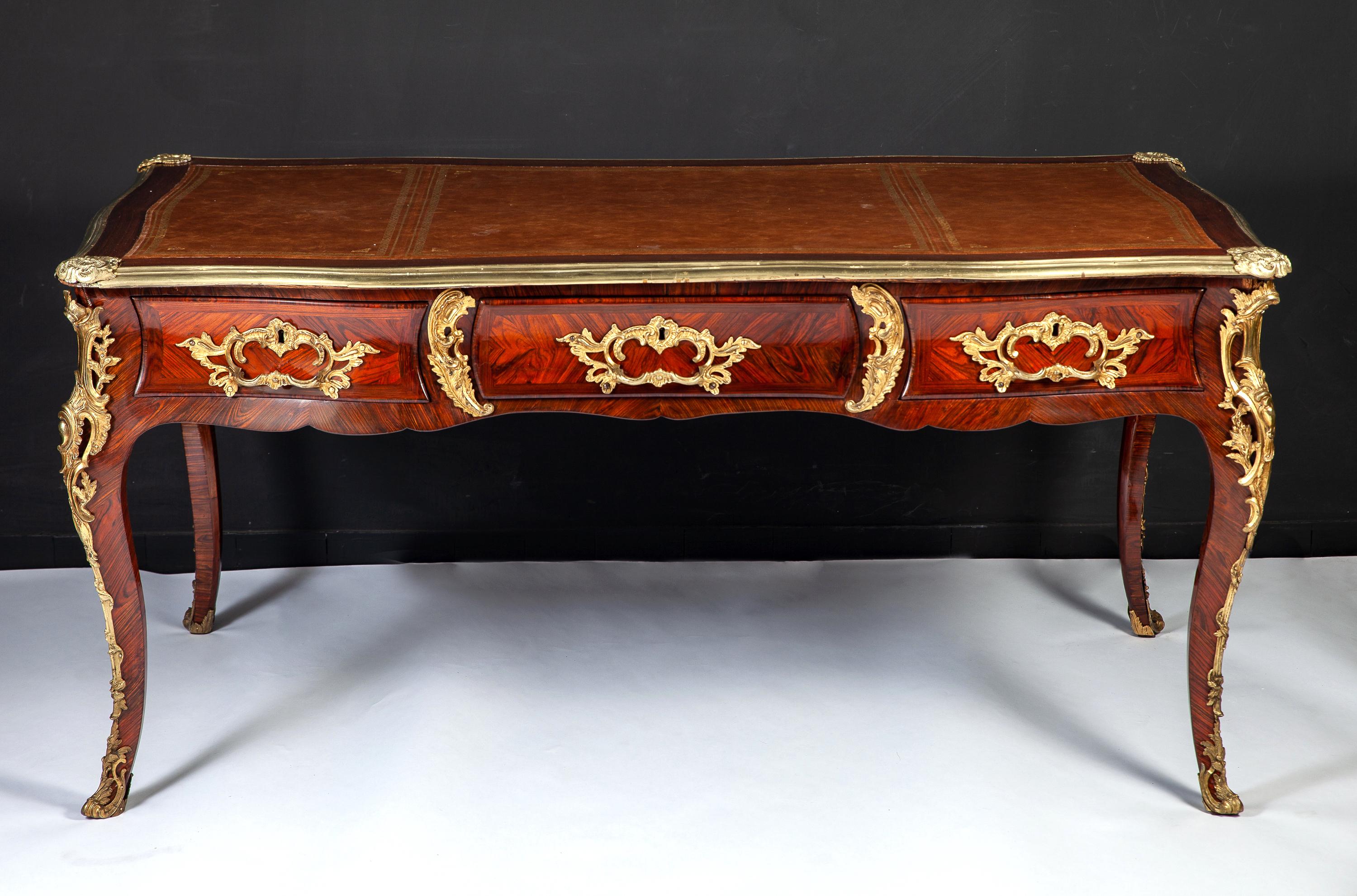 Superb quality French 18th century Louis XV, gilt bronze-mounted Kingwood bureau plat.
The shaped rectangular top inset with a tooled leather writing panel and fitted with three drawers to the undulating frieze, raised on cabriole legs.
Provenance