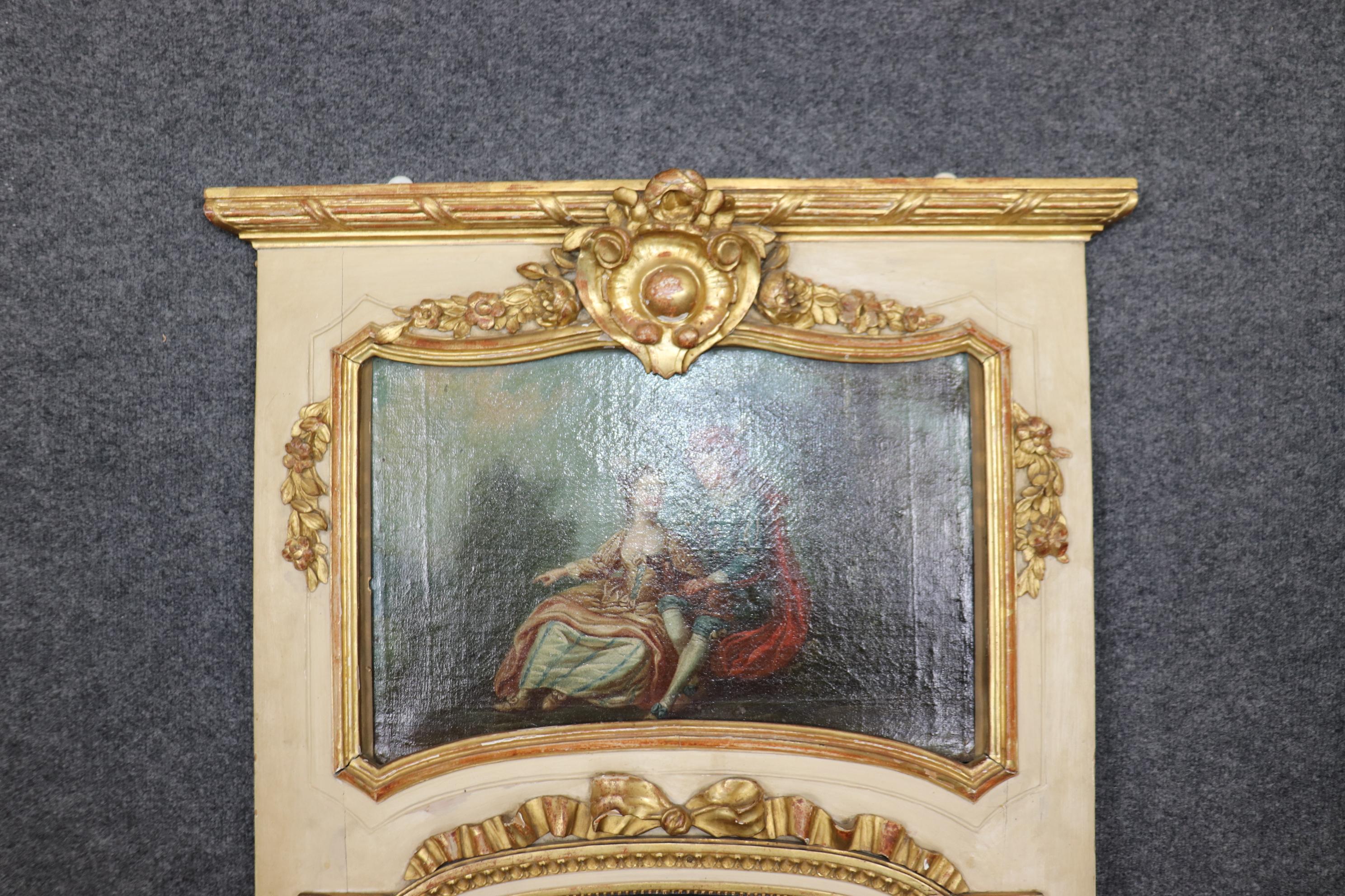 This is a superb and very rare French trumeau mirror with a delightful oil painting of a traditional courtship scene between a wealthy man and his eager betrothed. The mirror is in good condition with normal and age-appropriate signs of wear and use