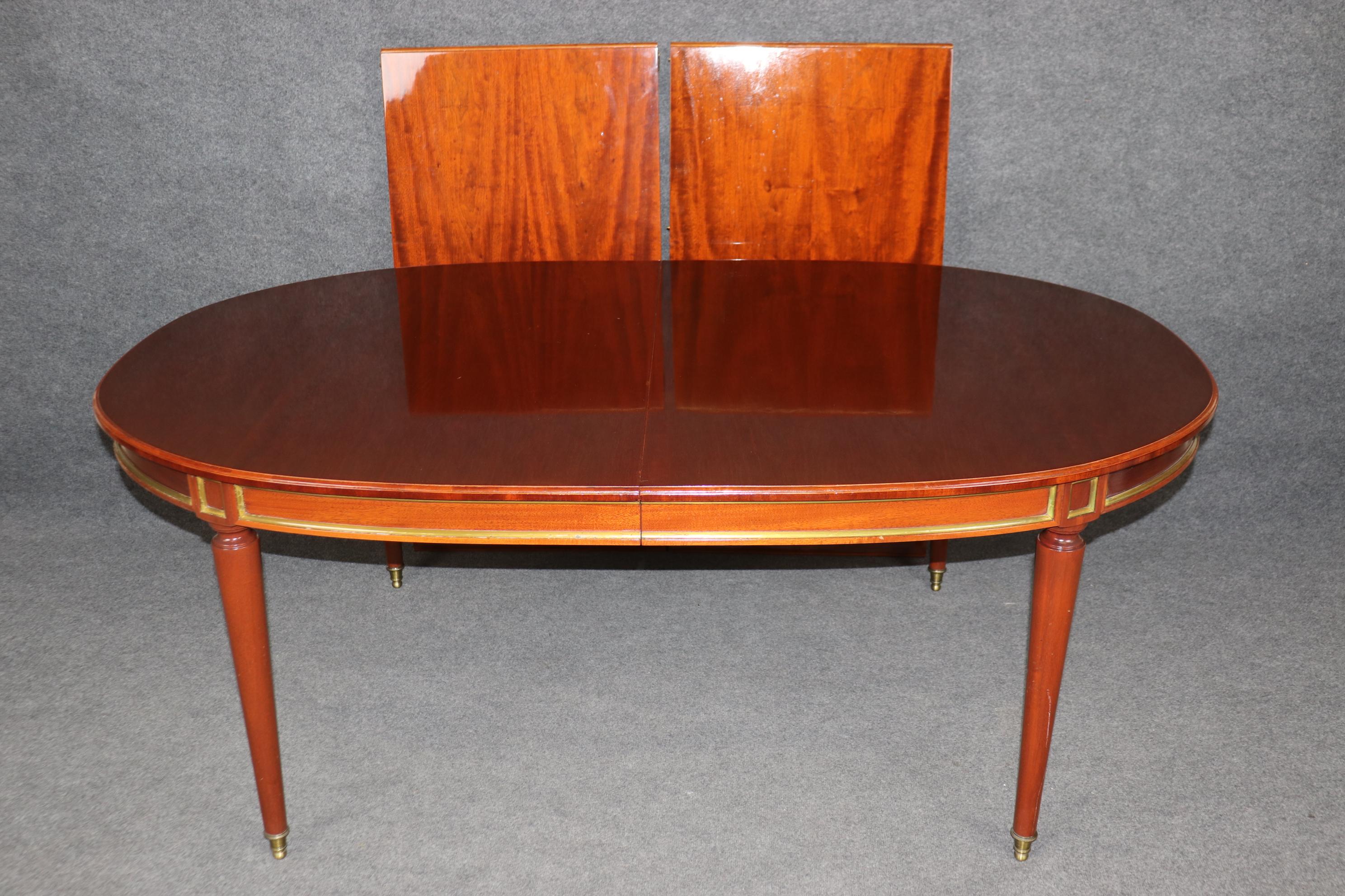 Français Superbe table de salle à manger en acajou de fabrication française attribuée à la Maison Jansen et ornée de laiton en vente