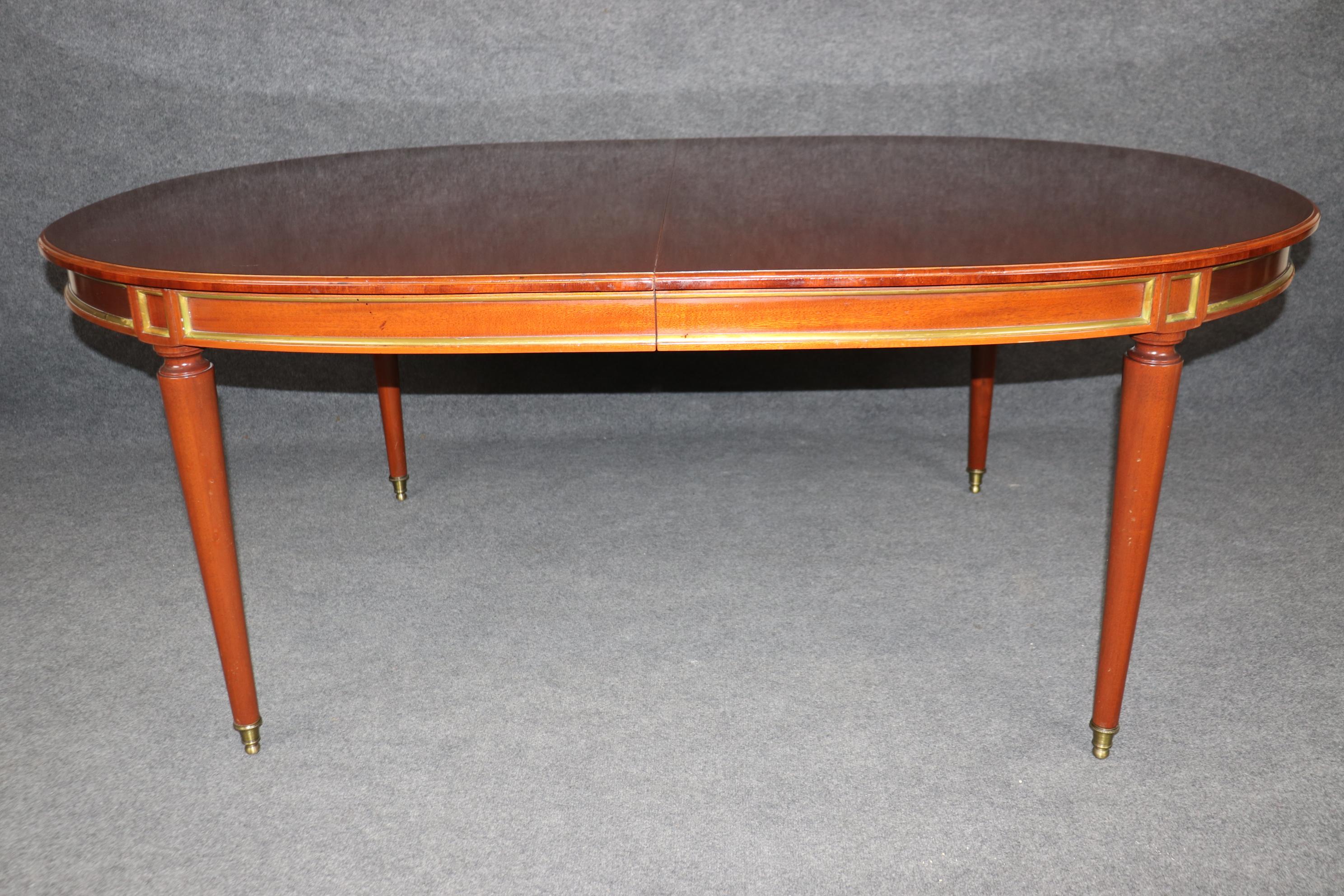 Milieu du XXe siècle Superbe table de salle à manger en acajou de fabrication française attribuée à la Maison Jansen et ornée de laiton en vente