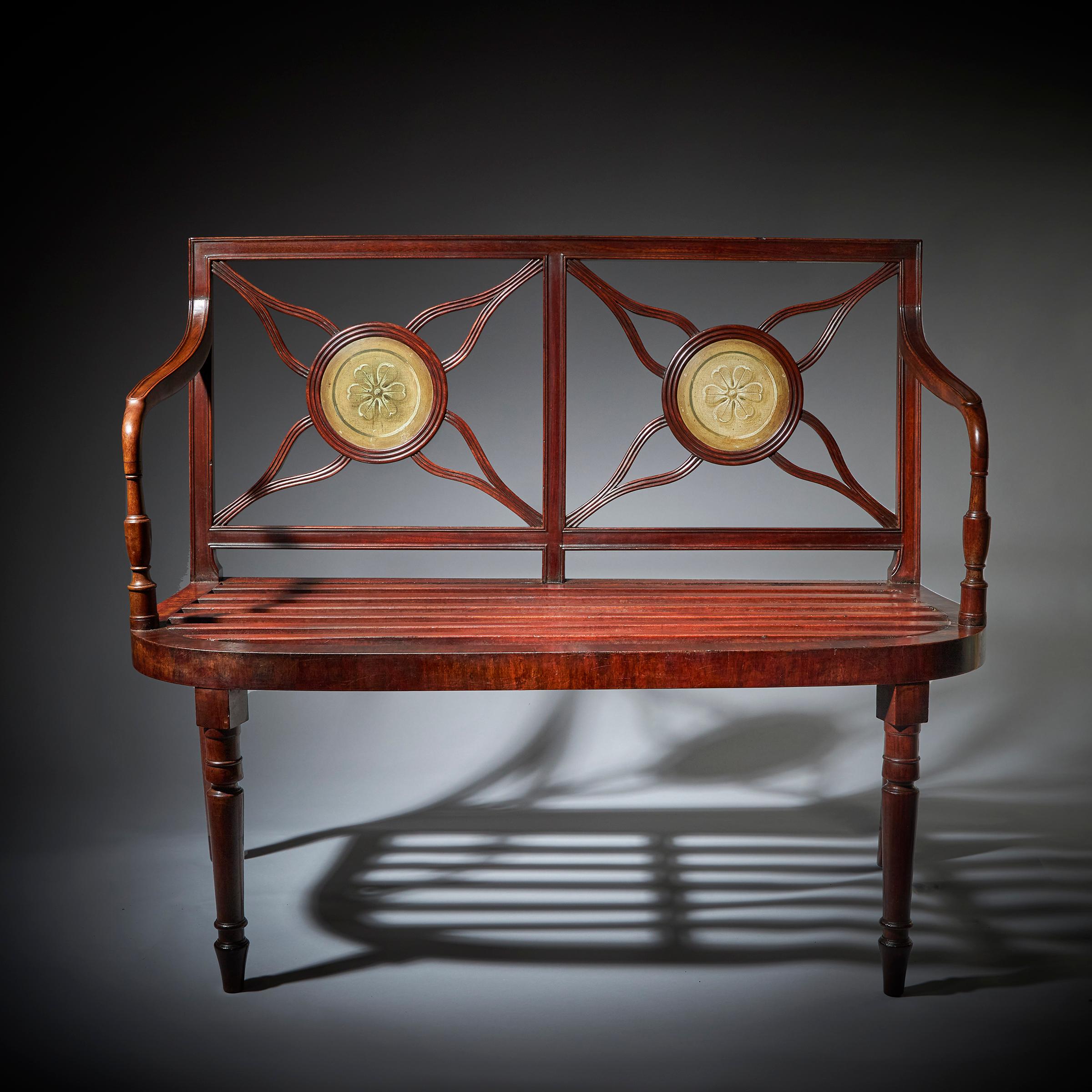 A fine and rare late 18th century George III mahogany hall bench/window seat in the manner of Gillows. 

The back, beautifully decorated with two hand-painted triple-moulded roundels depicting floral paterae, each joined by four fine and