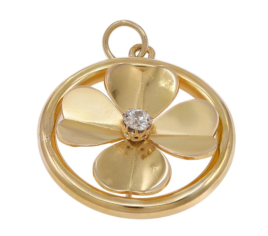 The perfect good luck charm/pendant.  The center, in a cut-out pattern, is a figural four-leaf clover, with heart-shaped beveled hearts.  Set with a faceted center old mine cut diamond.  Set in a solid gauge 14K yellow gold border.  1