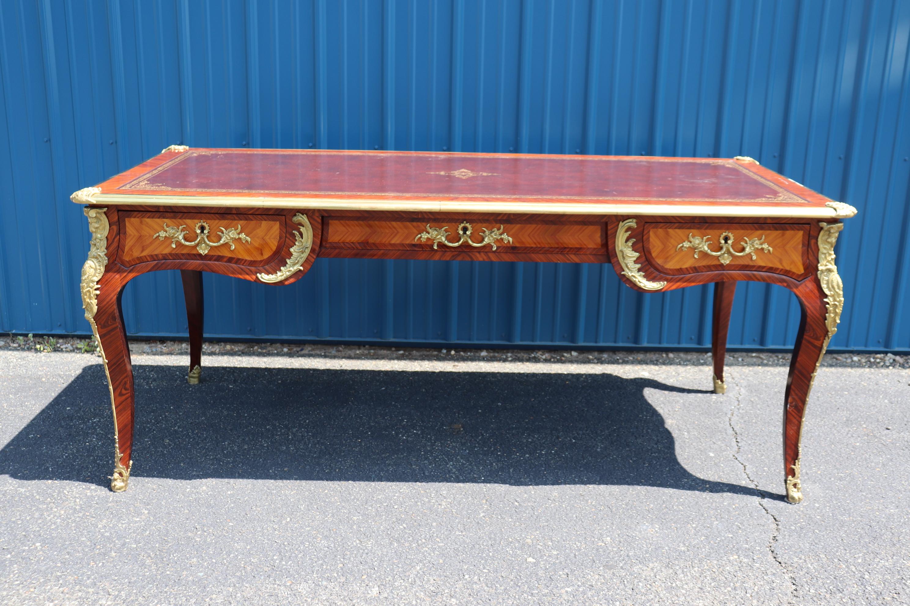 This is a spectacular desk with ornate bronze mounts and a gorgeous gold tooled leather top and an incredible rosewood case. The desk is a faux partners desk with drawers on one side and faux drawers on the other. Both sides are shown, and you can