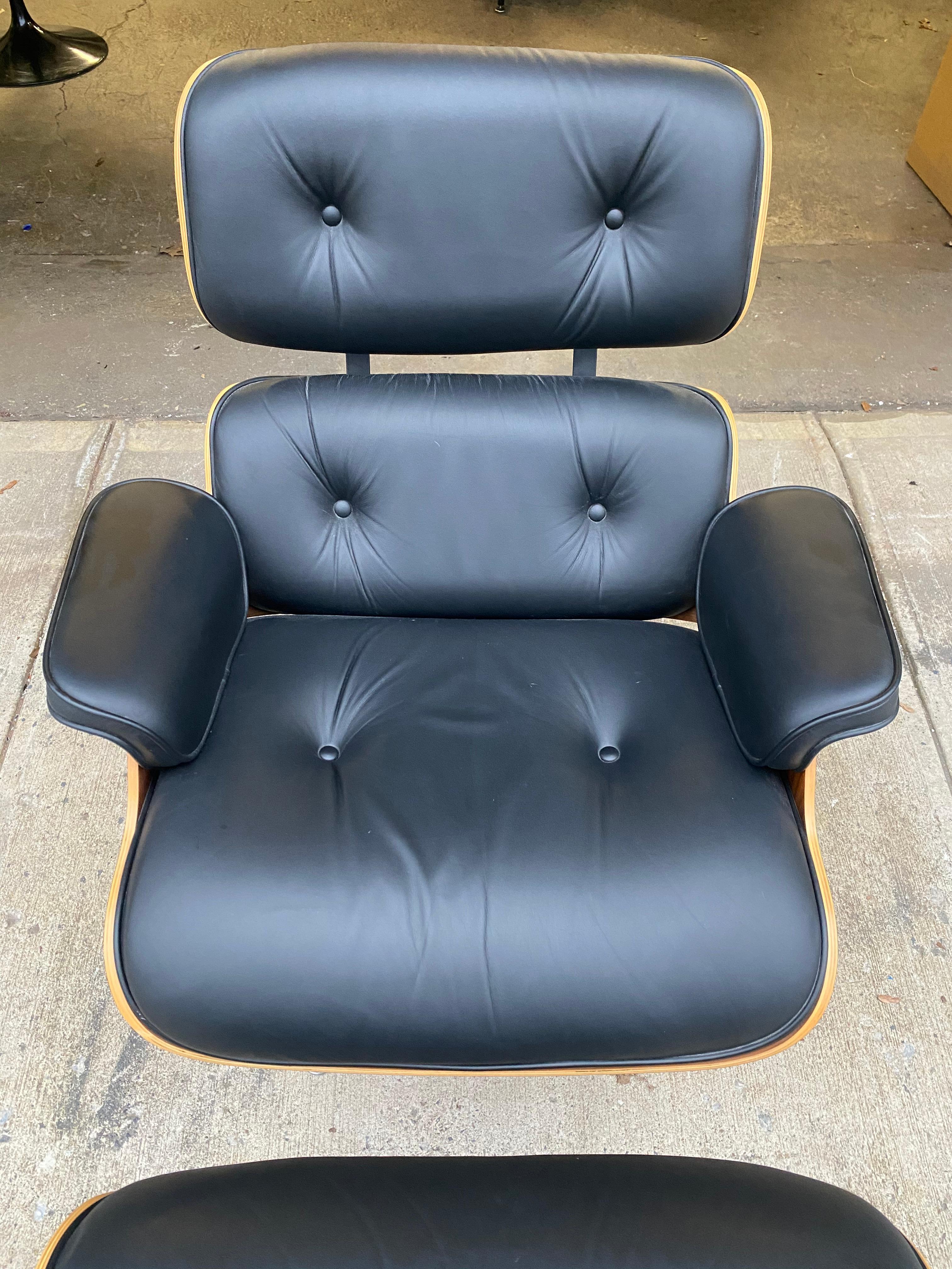 Gorgeous Classic Herman Miller Eames lounge chair and ottoman. Executed in original black leather and walnut shells. This chair was hardly used and the leather is like new. Signed and guaranteed authentic. Beautiful walnut tones and grain detail.