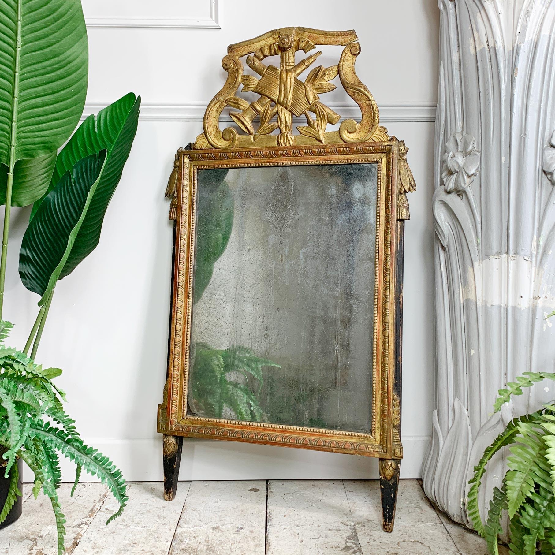 Datant d'environ 1770, ce magnifique miroir en bois doré est présenté avec sa plaque d'origine, qui a été roussie de la manière la plus merveilleuse, le bois sculpté et le décor en gesso doré, avec des nuances de rouge qui transparaissent à