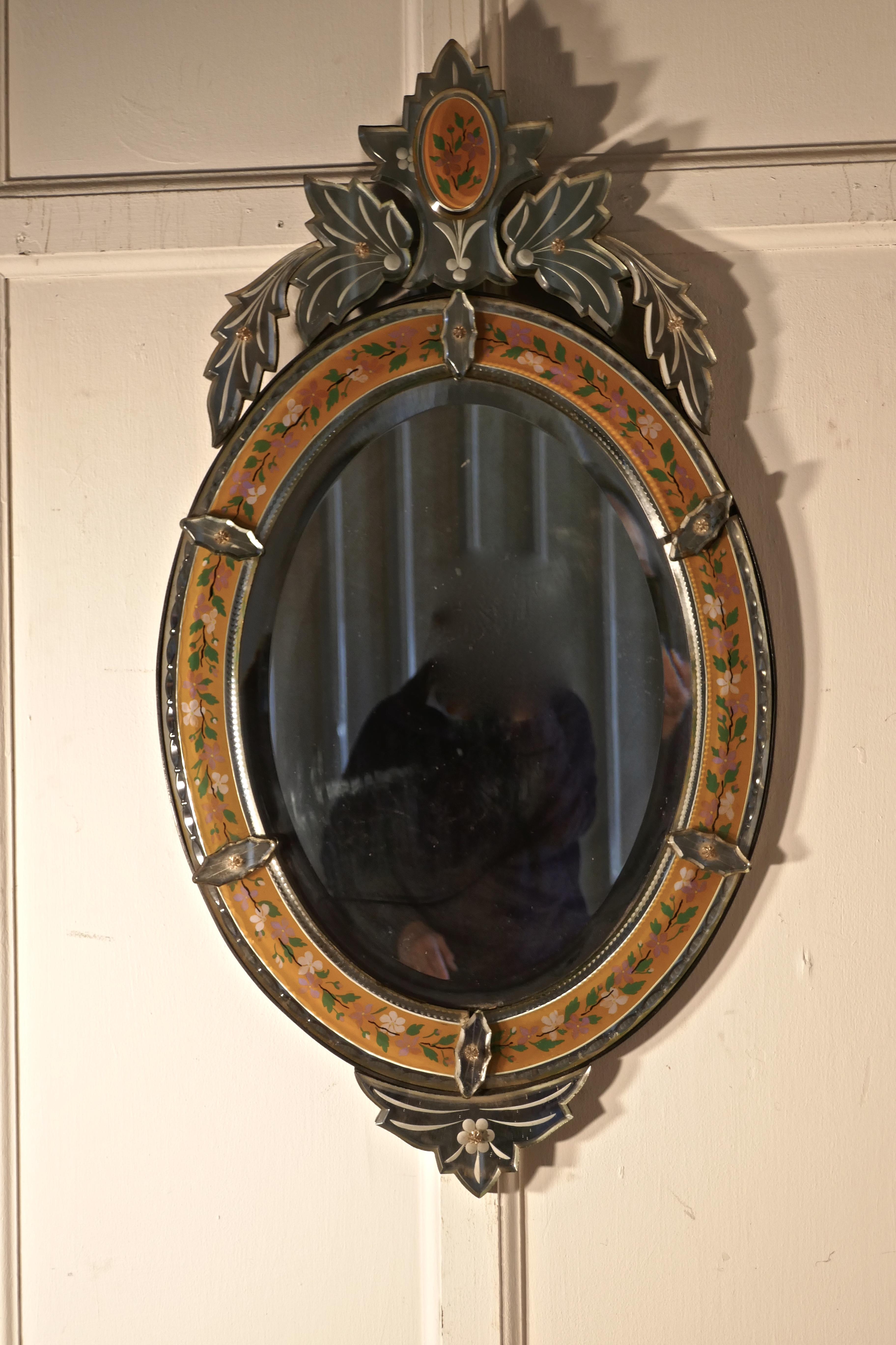 Superb Large Arts & Crafts Venetian Mirror

This is a very rare piece, it is absolutely original, the large Oval bevelled centre glass is bordered by a reverse painted glass surround, it has a tall leafy crest at the top and a smaller matching