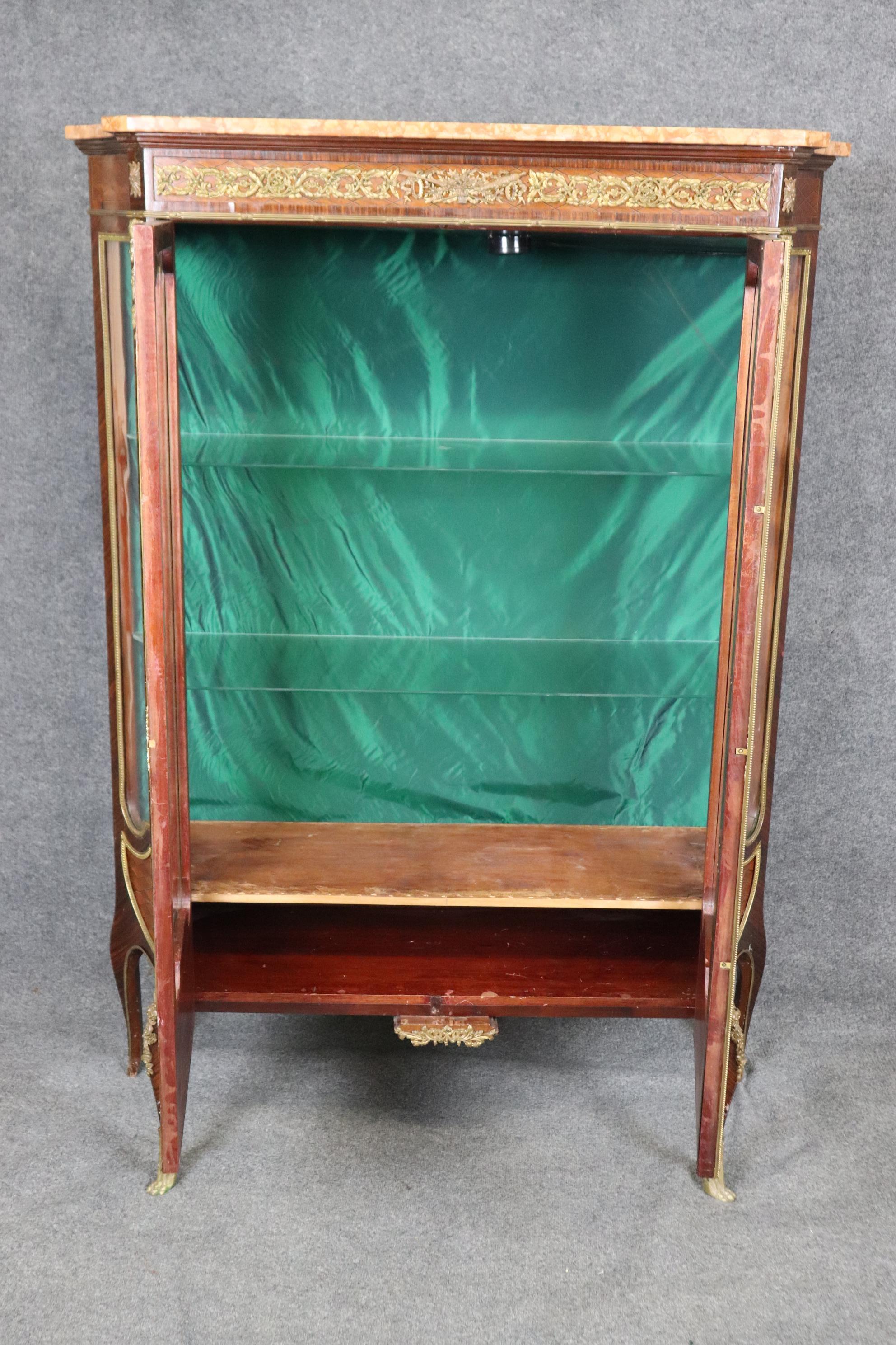 This is a monumental and stunning kingwood and walnut vitrine with incredible quality bronze and a gorgeous slab of coral hued marble on top. The cabinet has all of the hallmarks of Linke or possibly Joseph-Emmanuel Zwiener. The piece dates to the