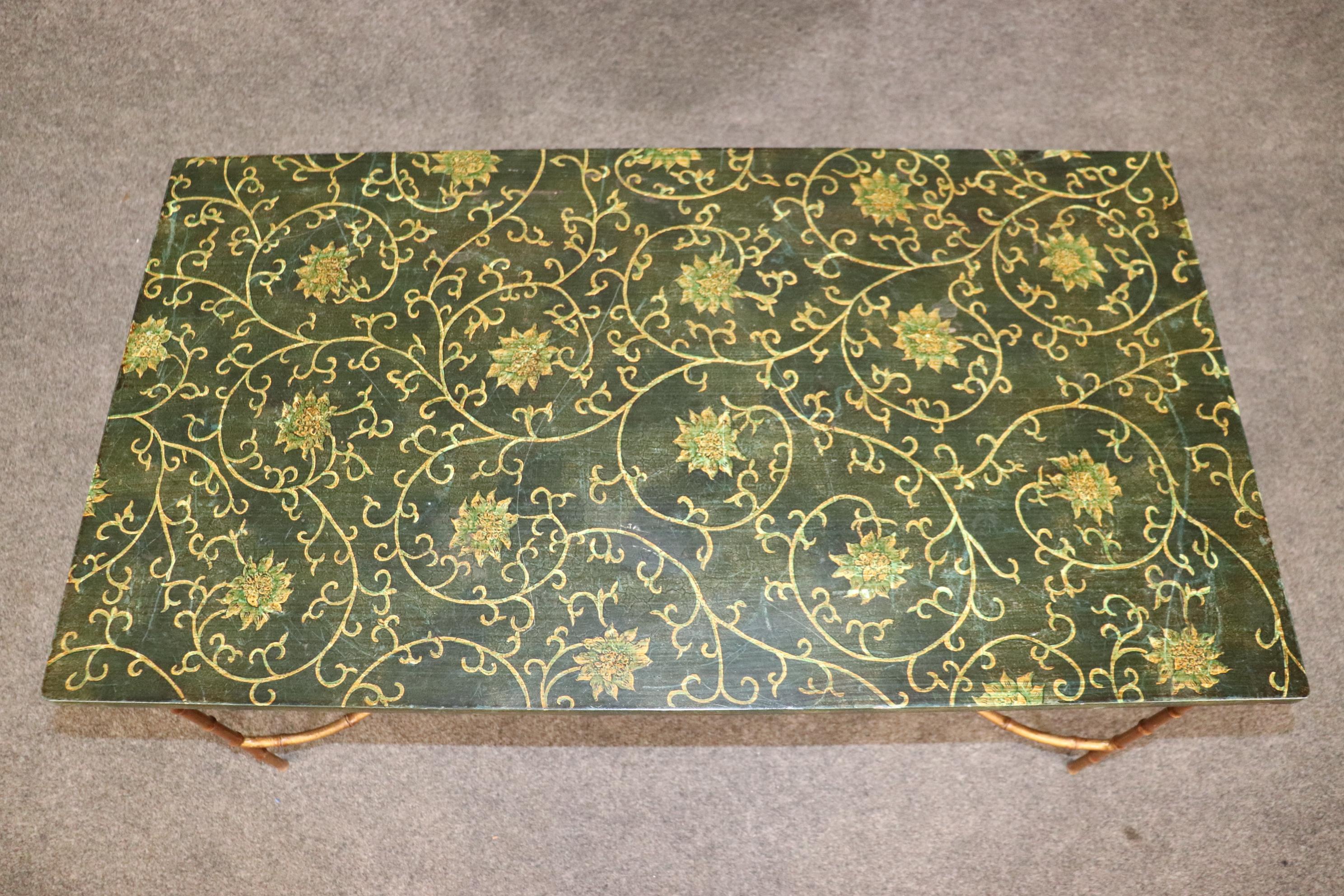 This is a stunning example of what we believe is a Maison Bagues coffee table with absolutely stunning paint decoration and a superb gilded steel base in faux bamboo. The table is in good original condition and measures 40 wide x 22 deep x 19 inches