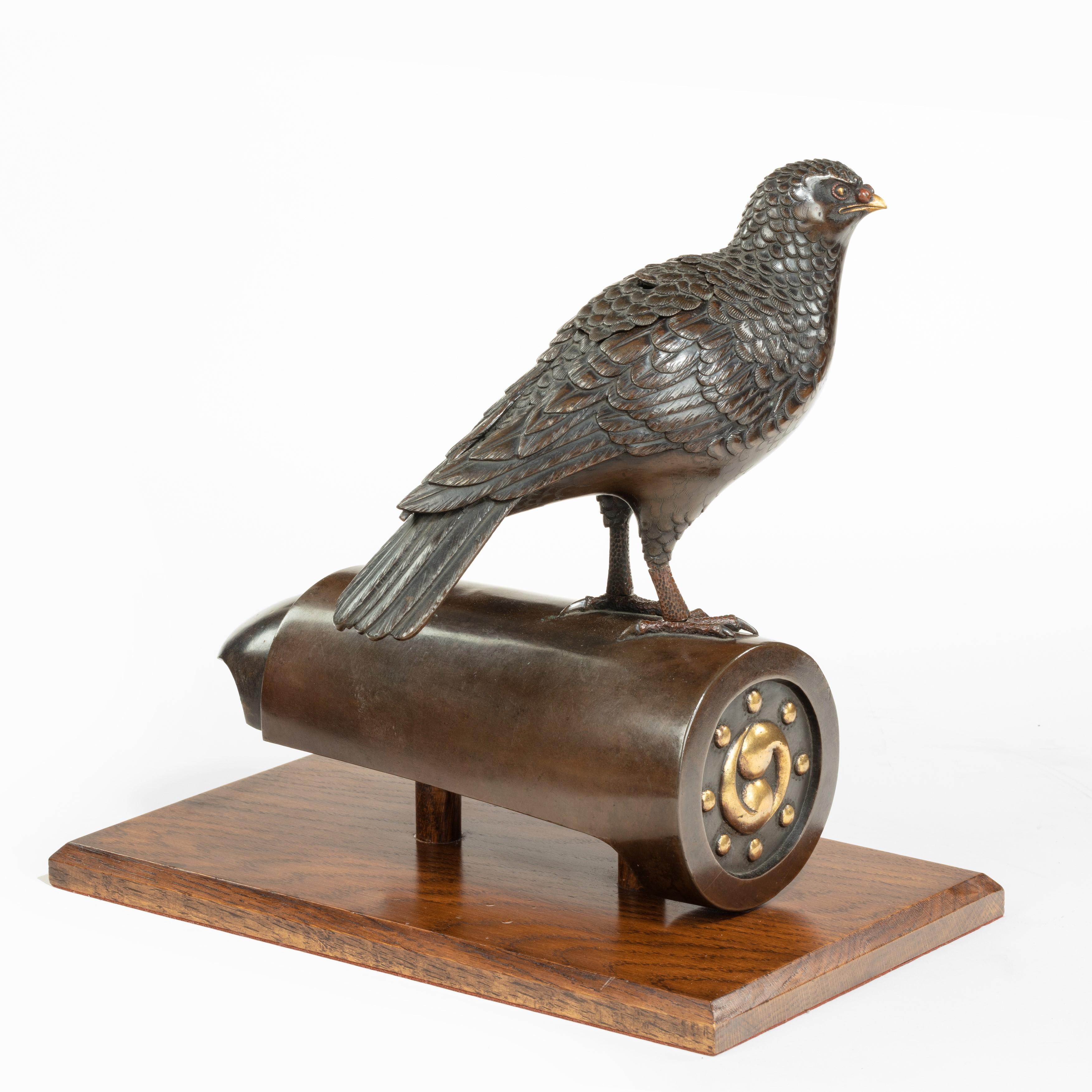 A superb Meiji period bronze koro in the form of a dove on a roof tile, the bird naturalistically modeled with gilt and shakudo eyes and beak with red nostrils, a section in the back with one feather ruffled to form the cover, the roof-tile cut back