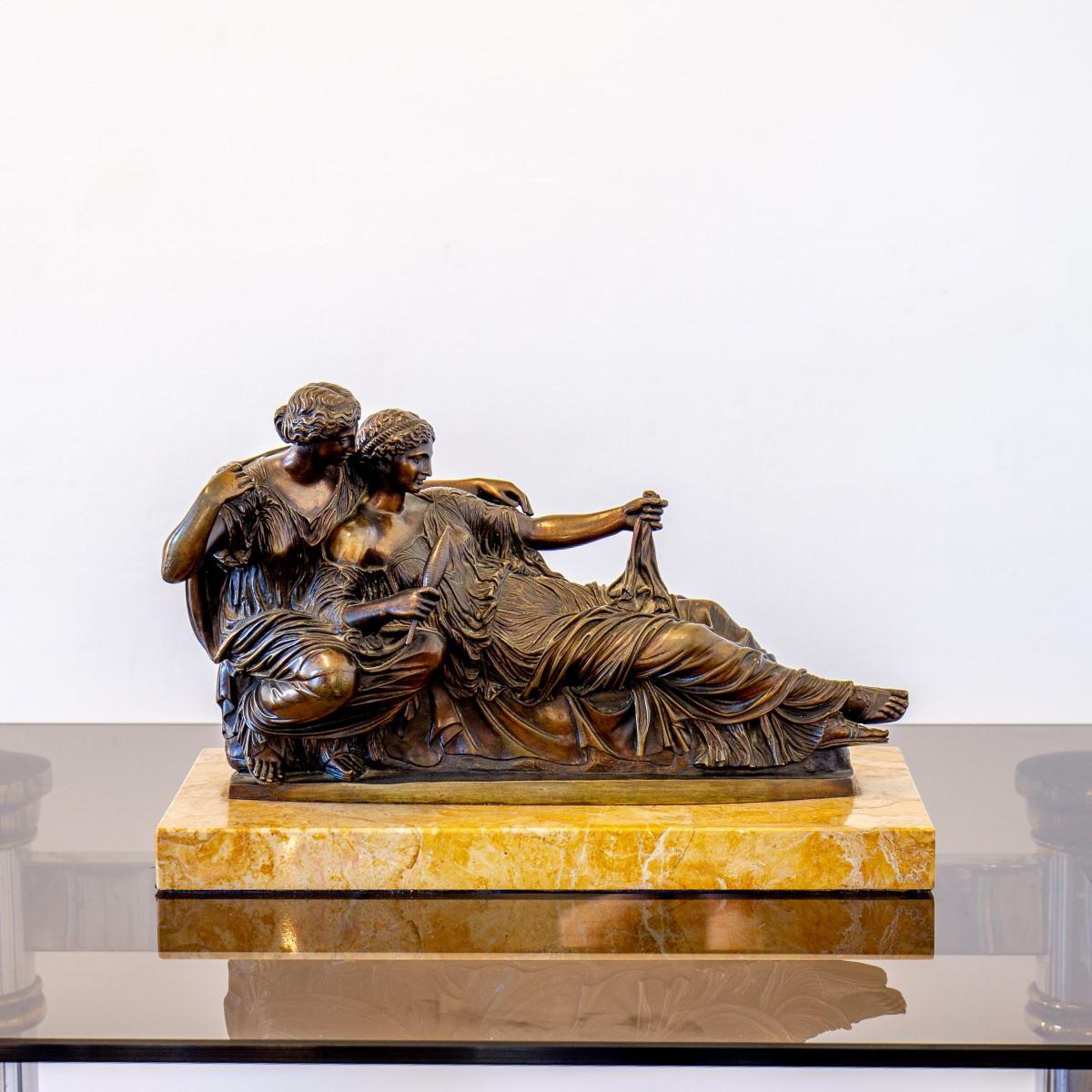 A superb mid 19th century bronze sculpture of reclining maidens spinning yarn, After the antique.

The ladies are mounted on a yellow marble base.