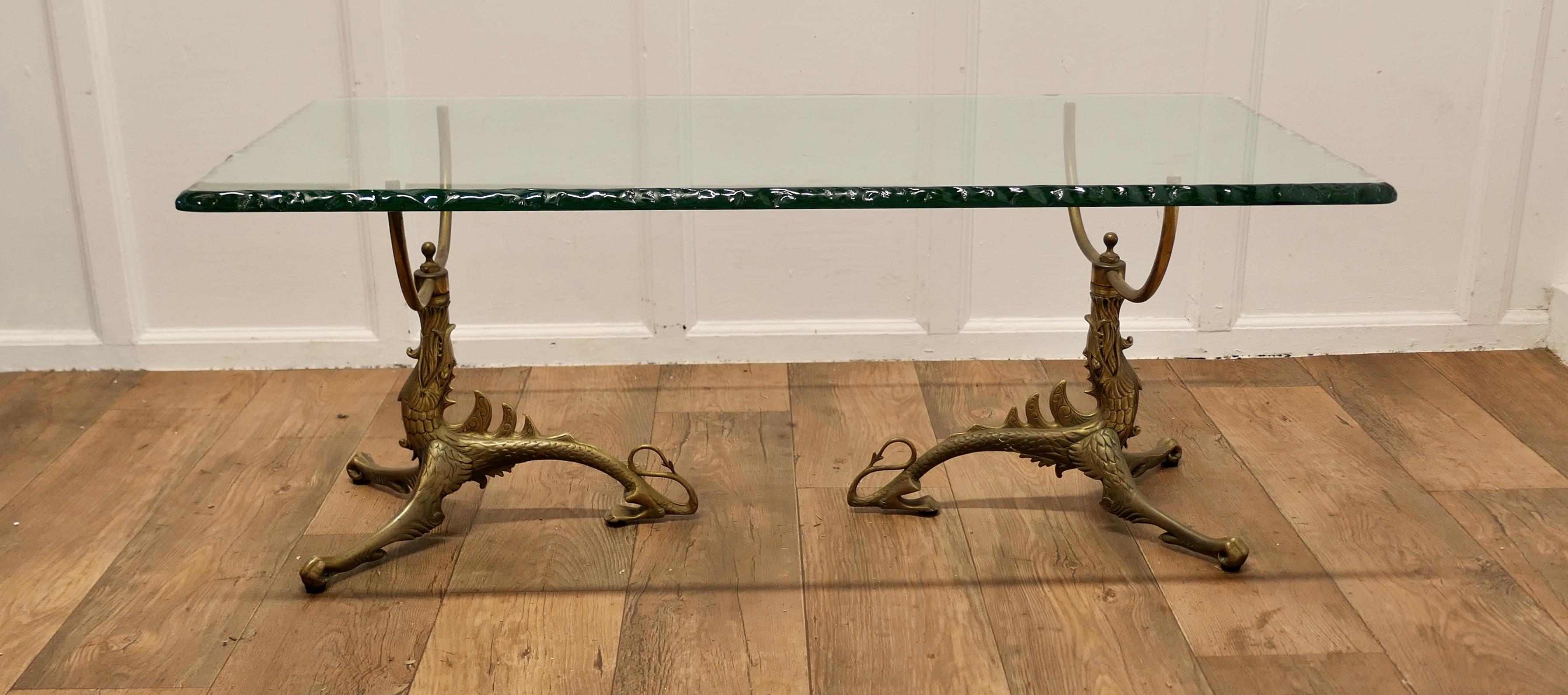 Superb Mid Century Brass and Glass Coffee Table

This design was first introduced by Jean-Danial Salvat, the 2 individual brass legs are in the form stylised dragons 

The top is rectangular with an irregular edge giving it superb shades of green