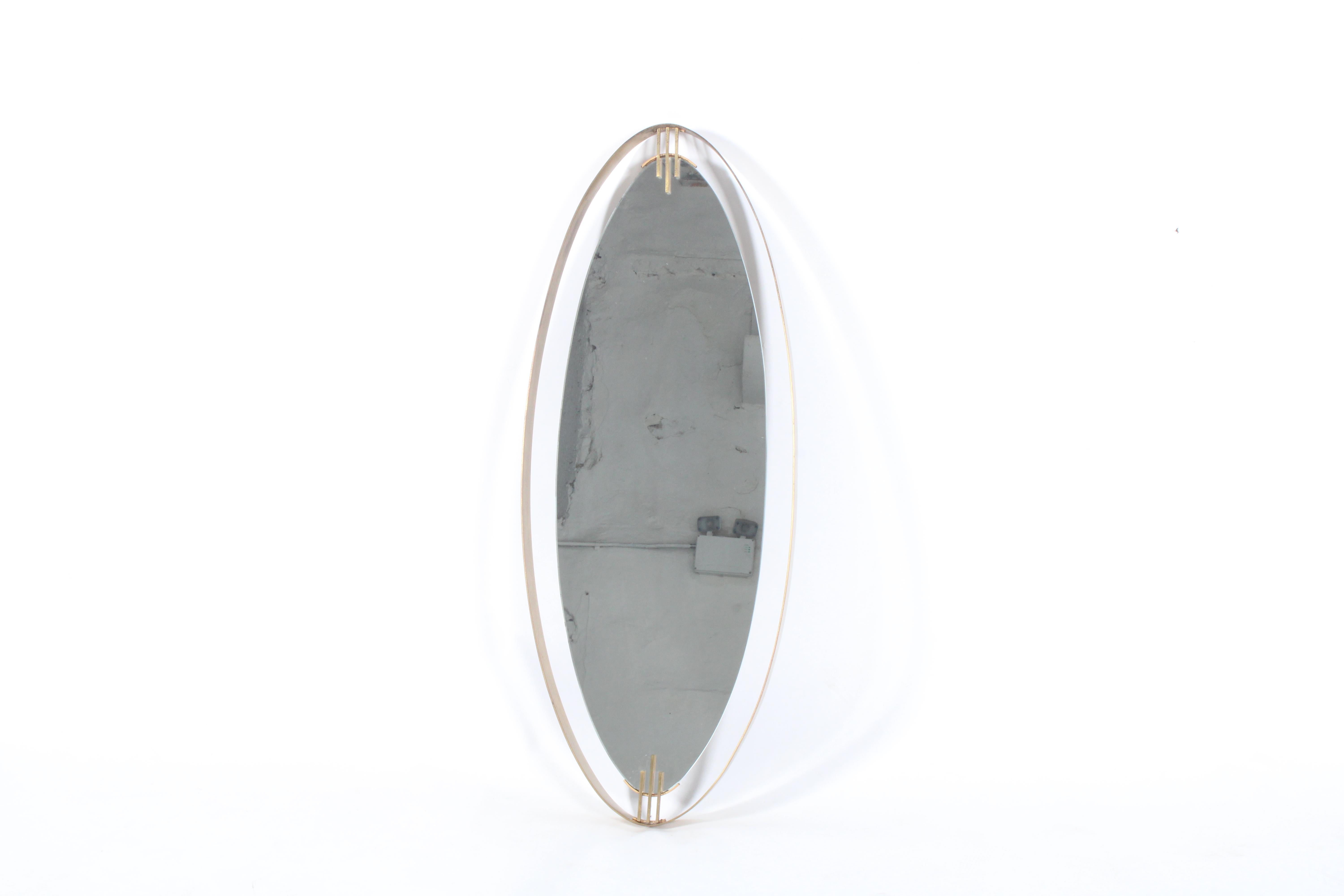 Stunning elliptical brass framed mid century Italian mirror with amazing wear and patina that adds character, charm, authenticity and style to this most attractive piece. Its unusual deep surrounding frame and lovely detailing to the top and bottom