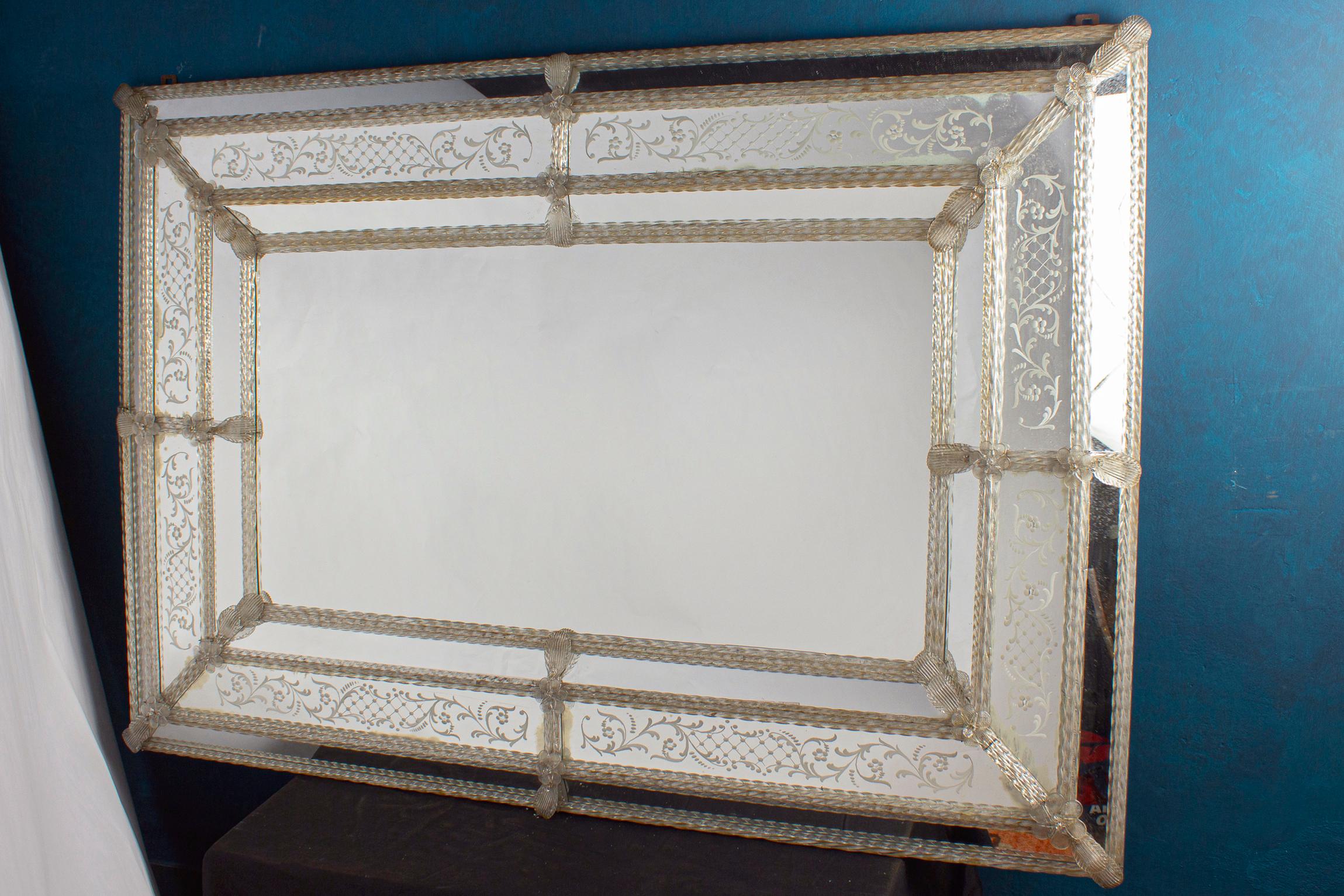 This beautiful Venetian mirror features etched floral motifs adorning the mirrored frame. Along the edges of the frame are glass rope accents and numerous glass flowers. You can install both vertical and horizontal.
Excellent vintage condition.