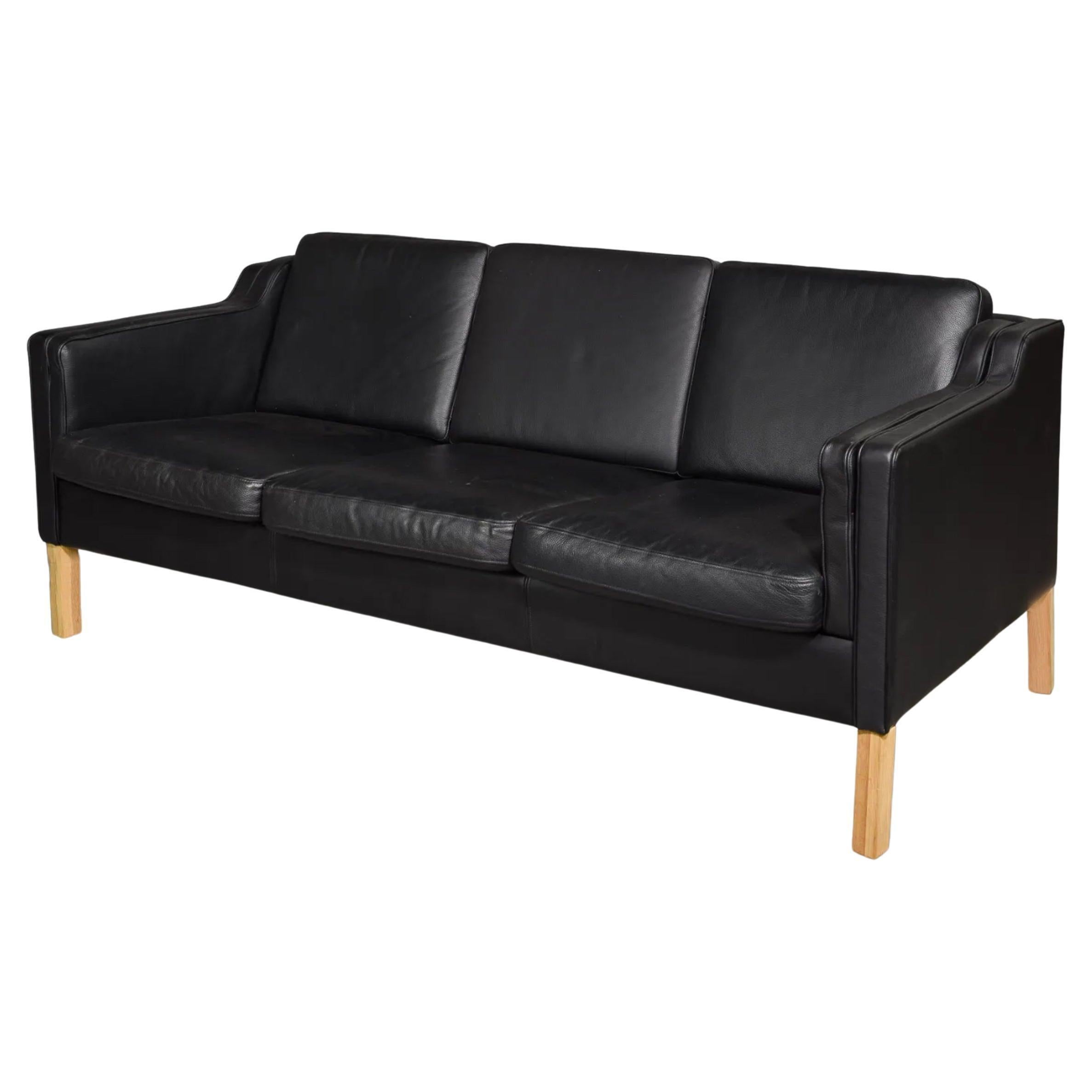 Splendido divano moderno danese di metà secolo in pelle nera a 3 posti con gambe in legno di Wood. Stile di Børge Mogensen. La bella pelle nera è morbida e mostra pochi segni di utilizzo, ma è ben rodata. Ottimo divano moderno danese. Ottime