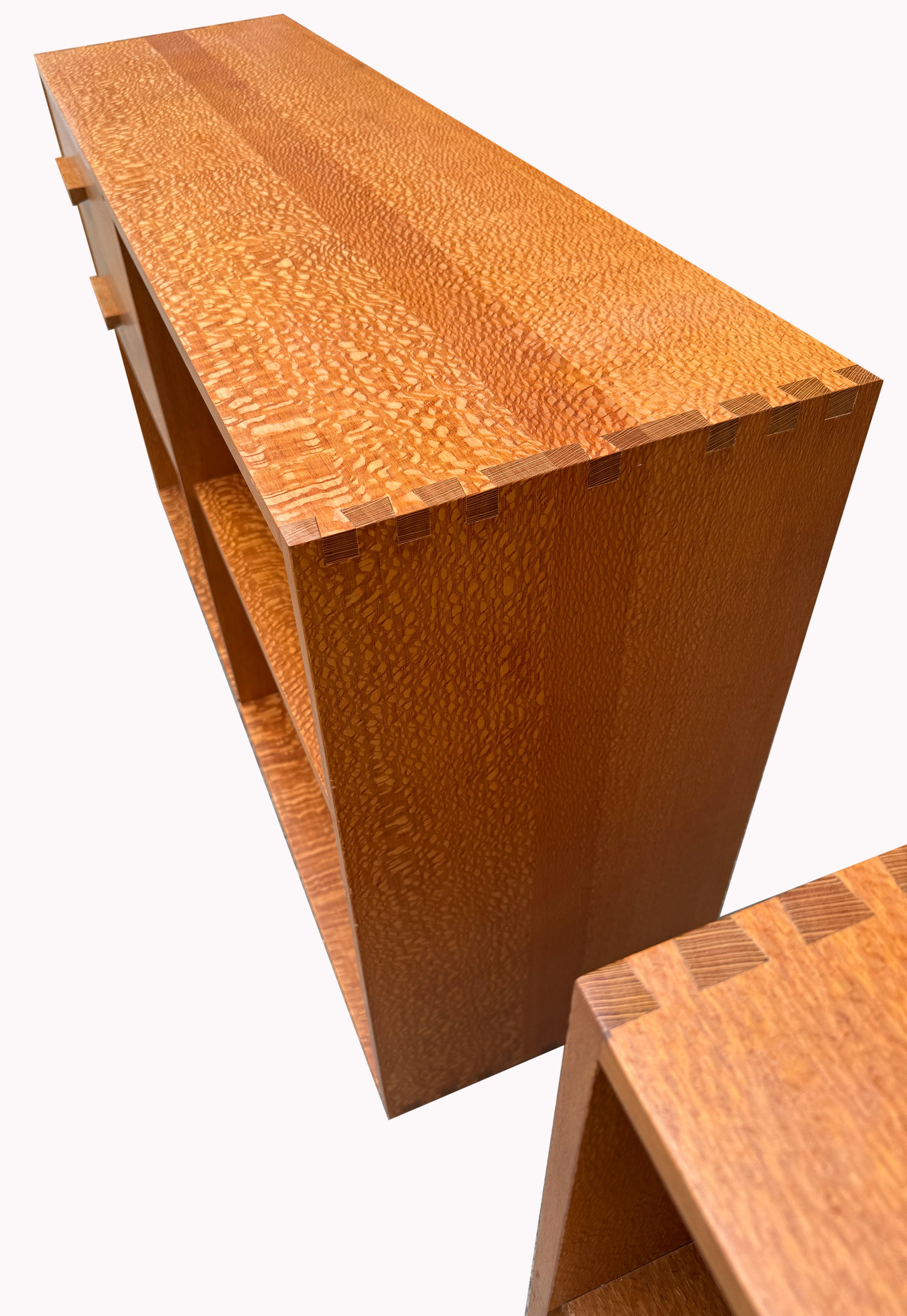 This striking pair of solid wood bookcases features two smoothly gliding drawers on each unit, showcasing quality dovetail construction. Crafted entirely from lacewood—also known as silky oak—these pieces are a rare find with exceptional grain