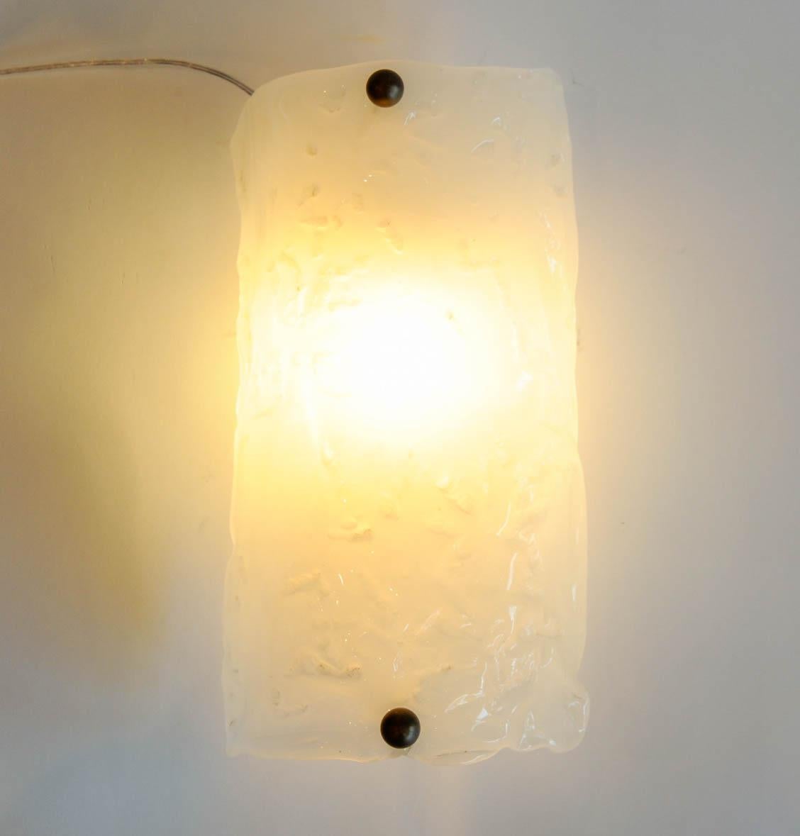 These three sconces are made of white Murano glass. One-light bulb on each sconce.