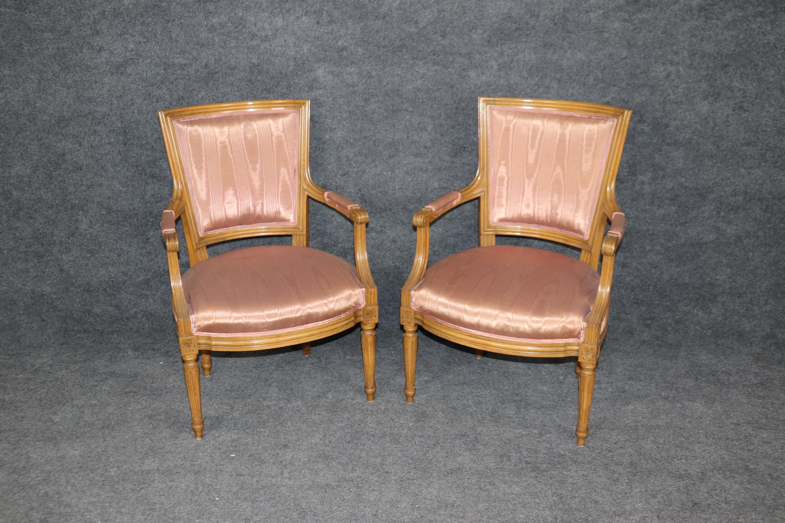 Voici une superbe paire de fauteuils Louis XVL en noyer peint au caramel. Les chaises sont joliment tapissées d'un tissu moiré rose blush et semblent être en bon état bien qu'elles puissent présenter des signes mineurs d'âge et des taches non