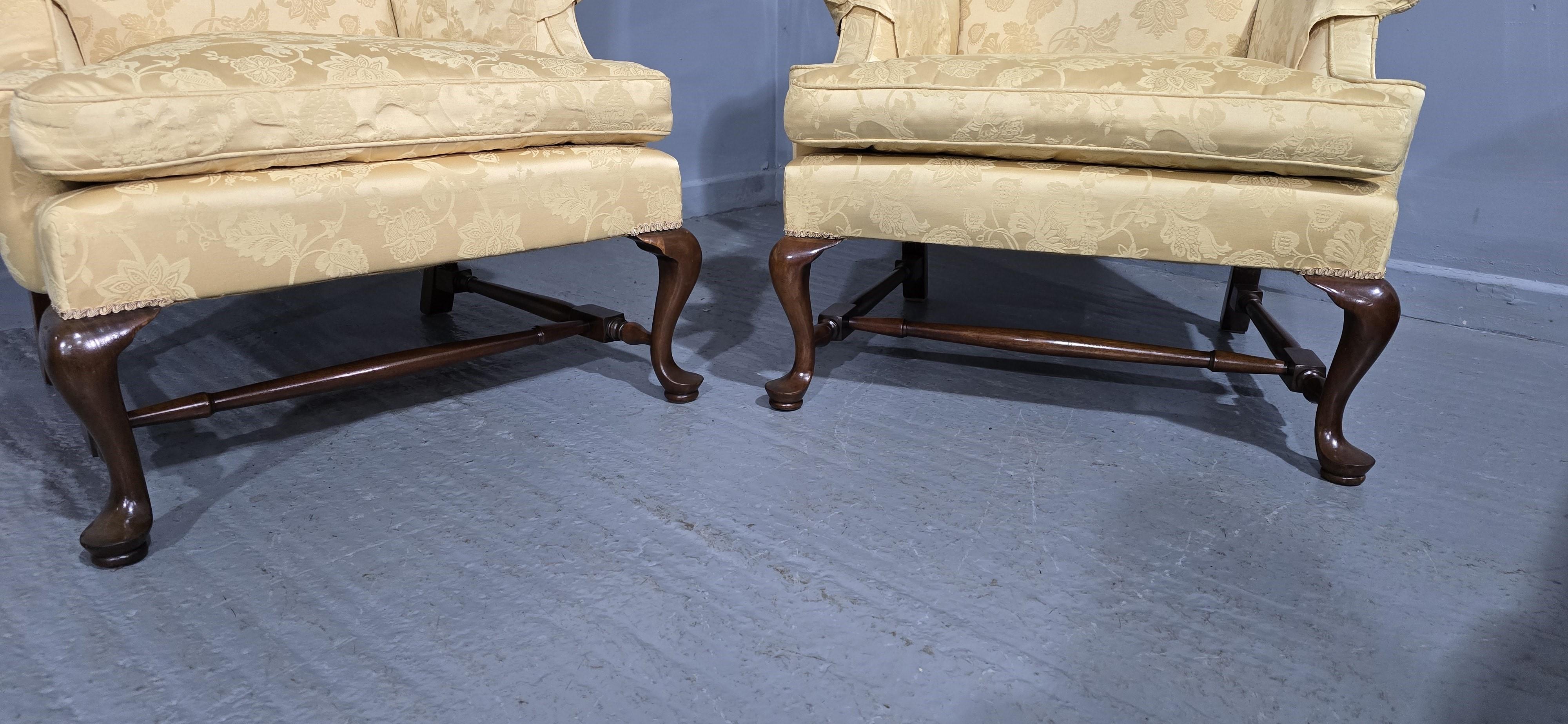 Excellent pair of mahogany wing backed library armchairs, cabriole front legs on pads, under stretcher and outswept back legs, flock seat pad, pale gold damask fabric, and arm protectors, in overall excellent condition.

You are welcome to view this
