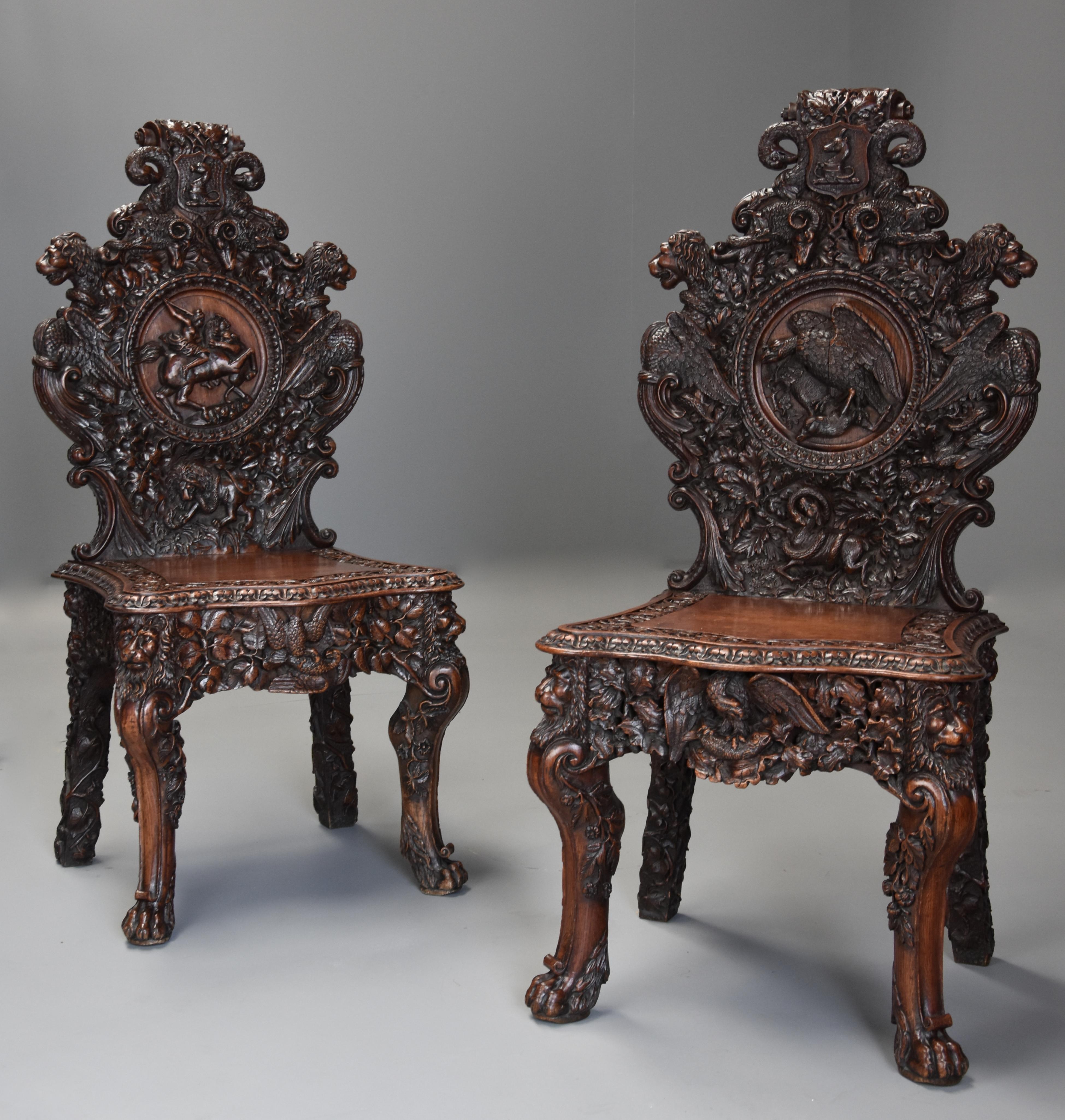 A superb pair of mid-19th century exhibition quality carved oak chairs of large proportion.

This pair of chairs consist of superbly and profusely carved backs with carved scrolling and foliate decoration to the top with carved armorial and carved