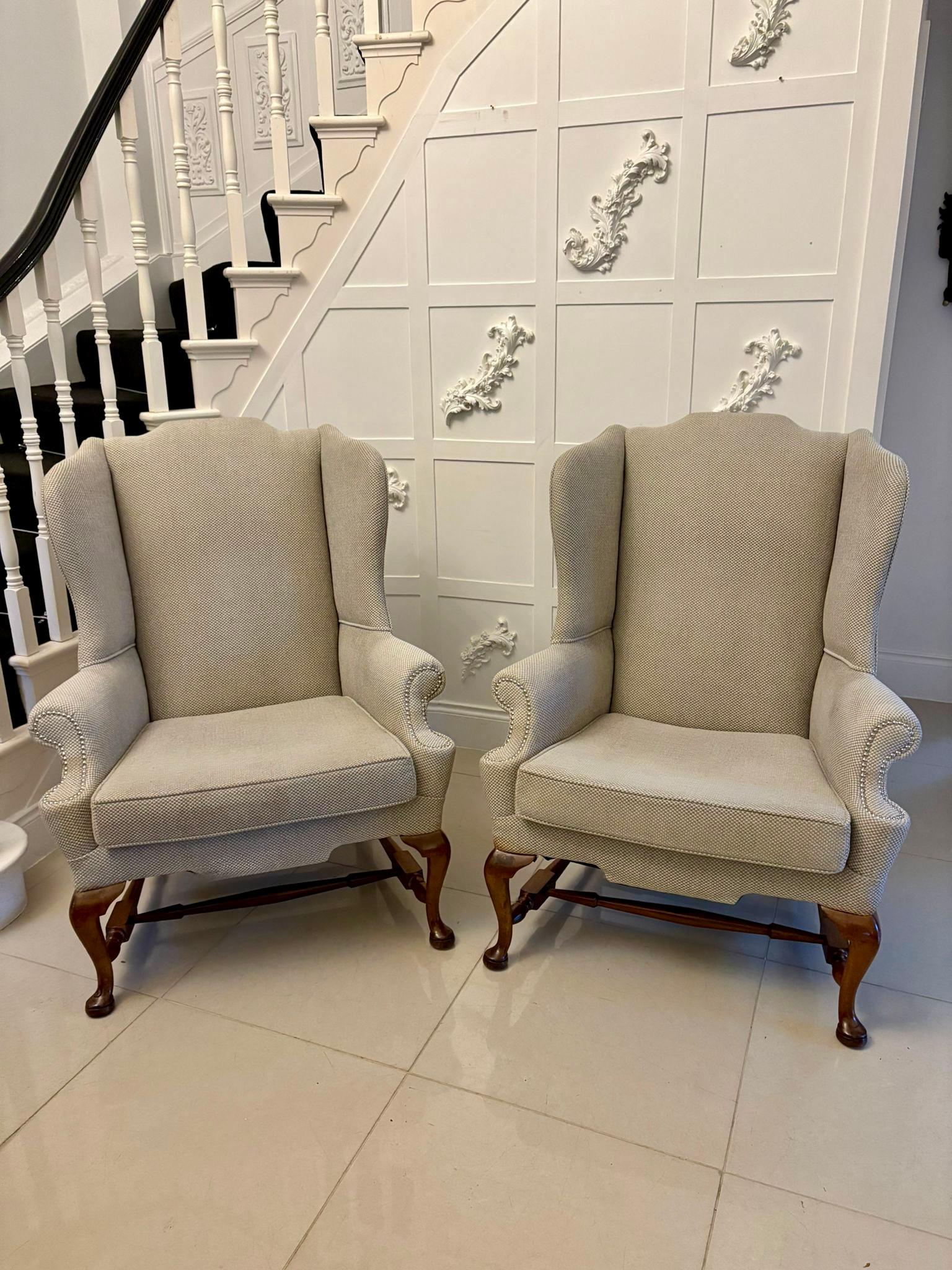 Superb pair of antique wing chairs on quality mahogany cabriole legs having drop in seats standing on quality mahogany shaped cabriole legs with pad feet, out swept back legs united by turned mahogany tapering stretches. Upholstered in a grey fabric